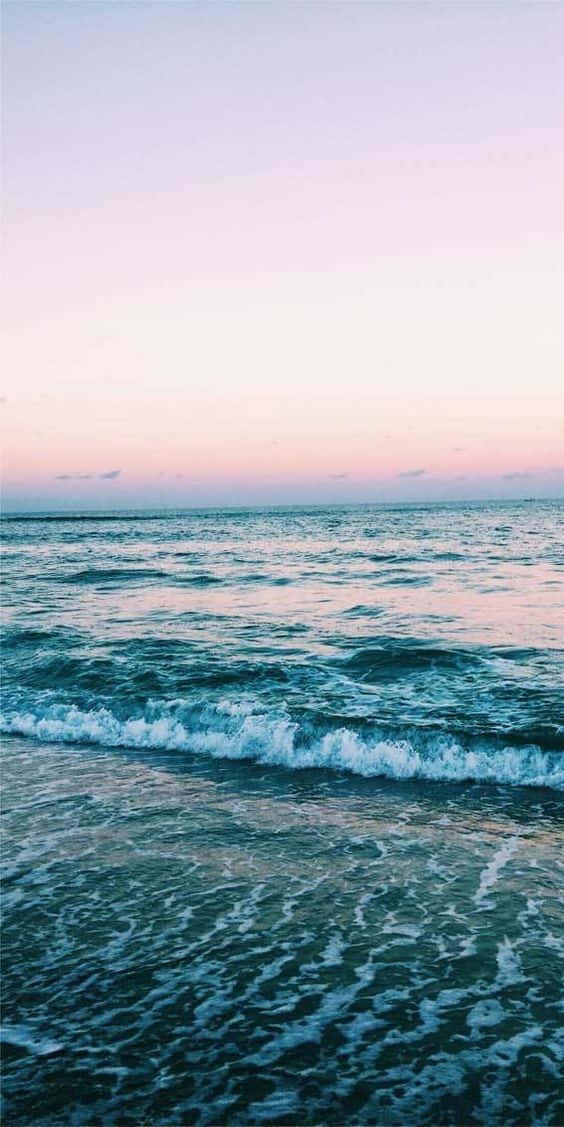 日落時分的海浪，帶有粉紅色和藍色色調