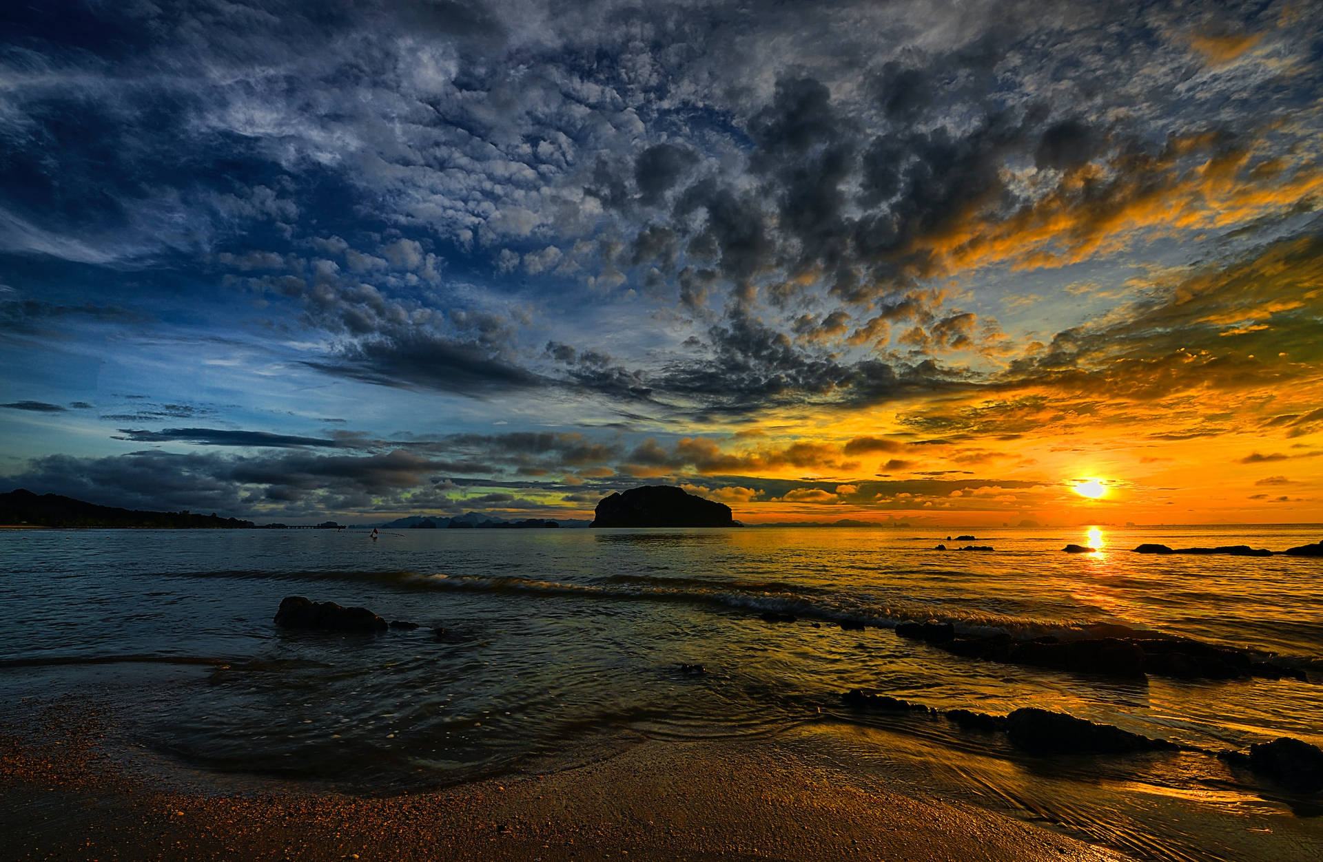 海洋上的夕陽，伴隨著戲劇性的雲彩和岩石海岸