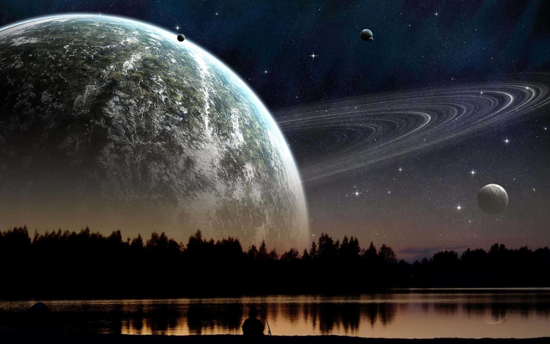 美麗的自然風景 壁紙 — 一個孤獨的身影坐在湖邊，在暮色中仰望星空宇宙中一顆巨大的外星行星和一個有環的世界。