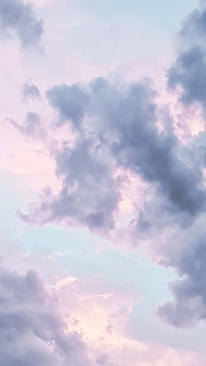 美麗的藍天 壁紙 — 柔和的粉彩雲朵飄過融合薰衣草紫、粉紅和淡藍色調的暮色天空。