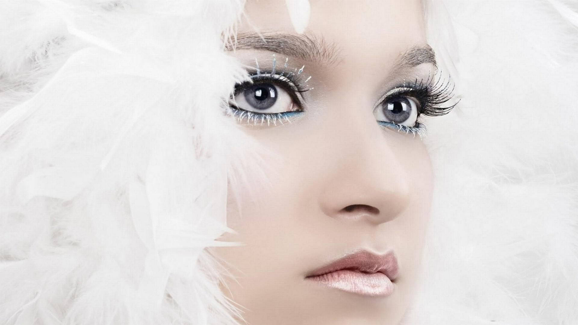 女士臉部特寫，帶有白色羽毛和閃亮眼妝。