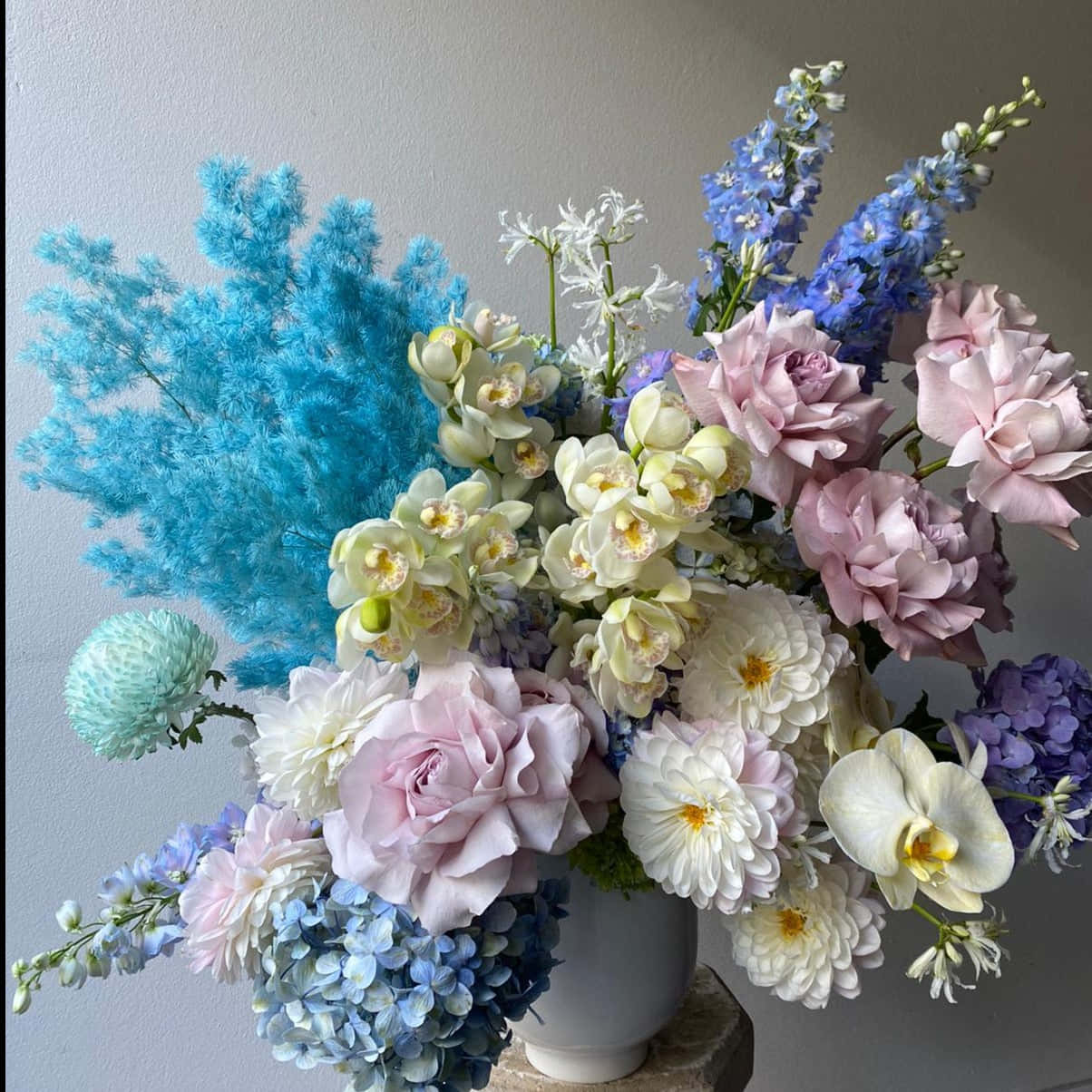 粉彩花束，藍色、粉紅色和白色花朵在白色花瓶中。
