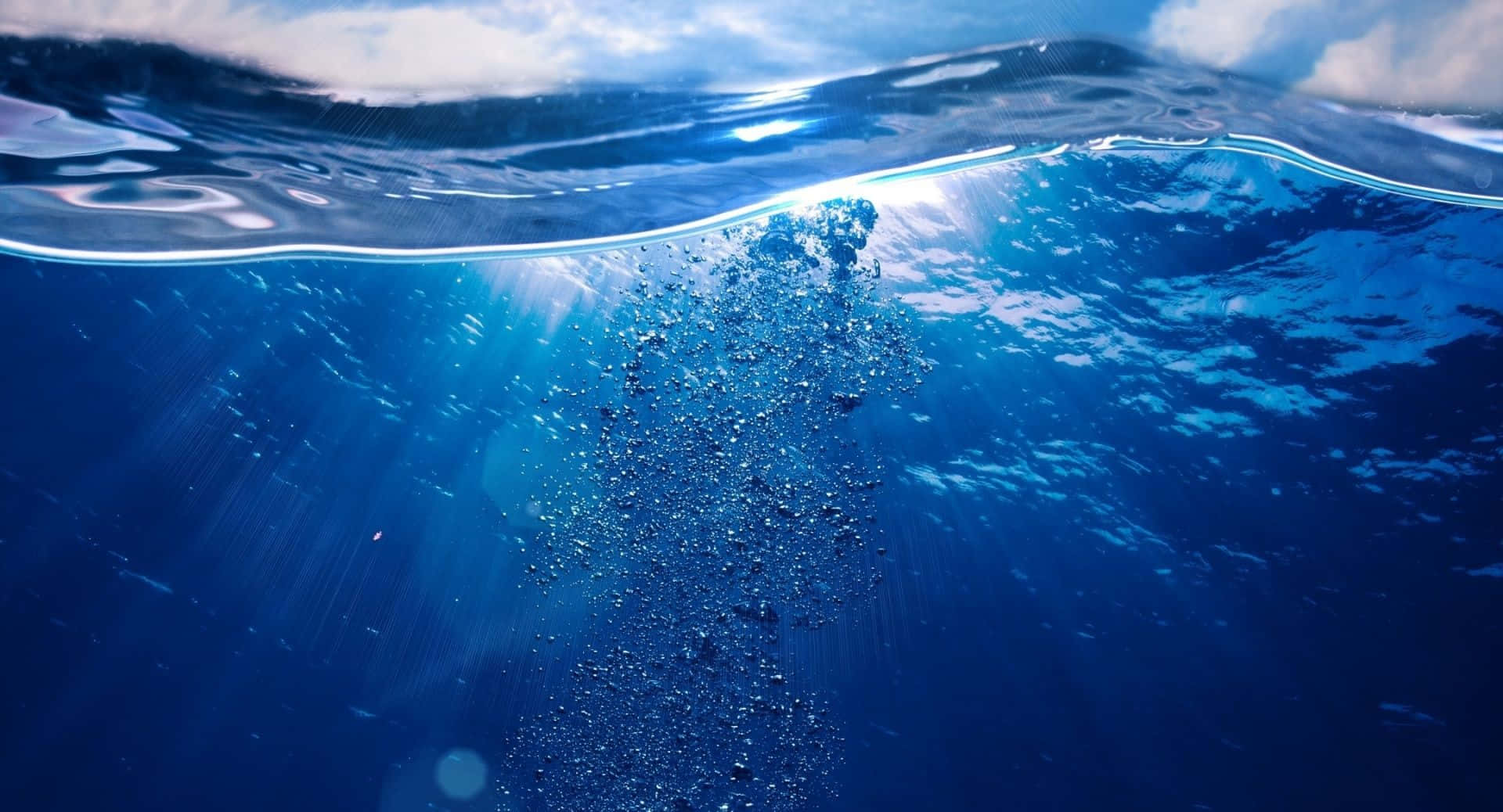 陽光穿過海面，照亮水下上升的氣泡。