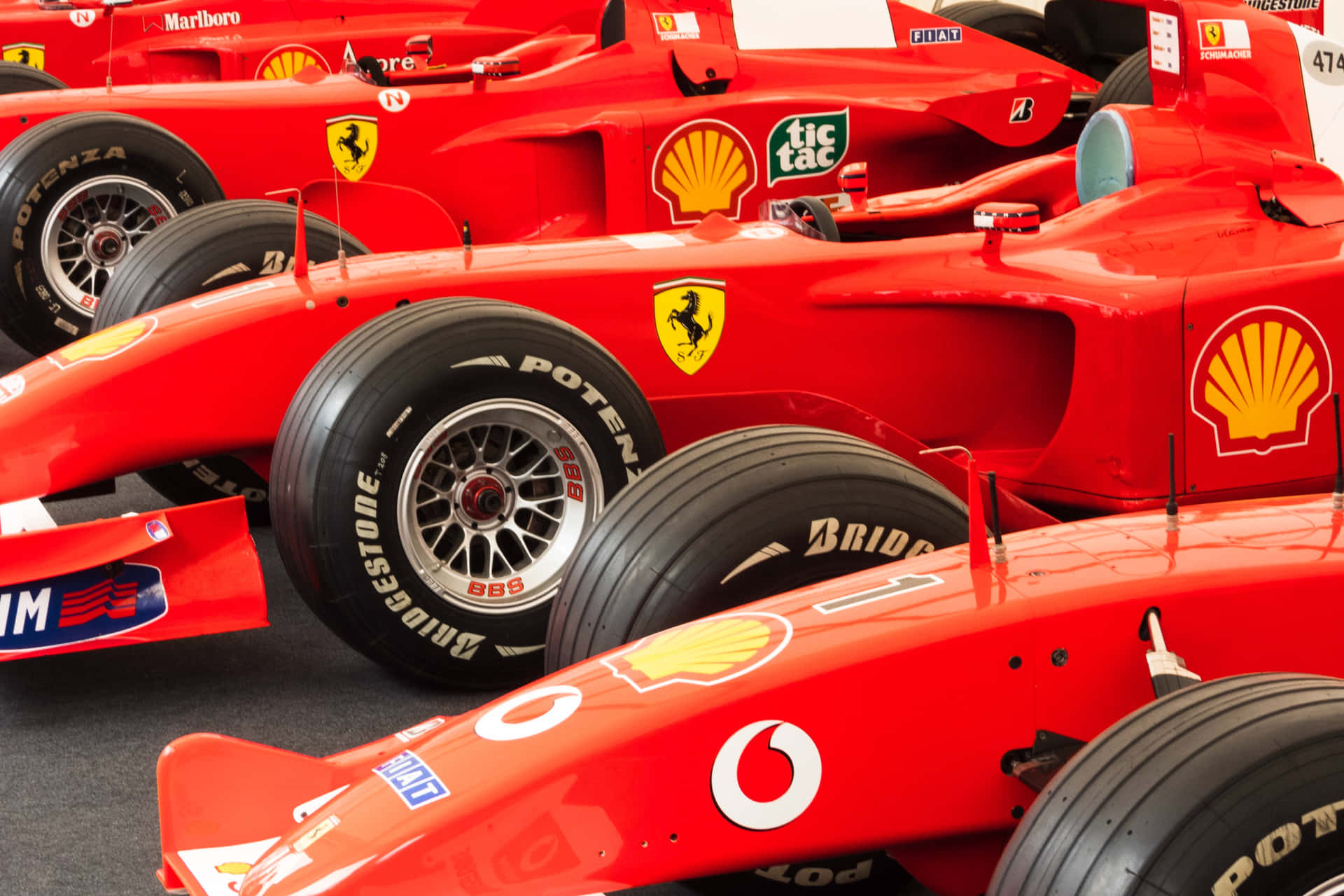 紅色法拉利F1賽車配備Bridgestone輪胎和Shell標誌排成一排。
