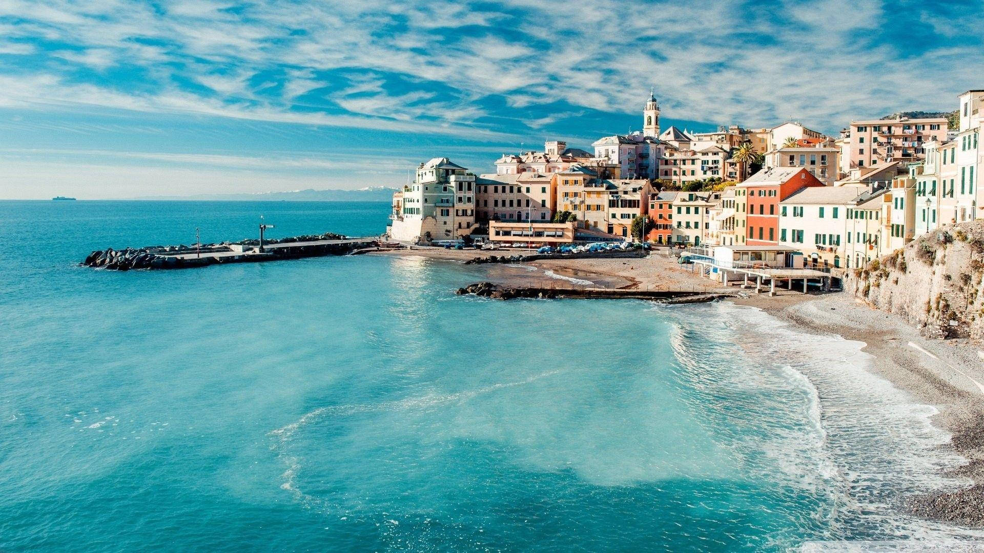 義大利海景 壁紙 — 充滿活力的沿海村莊，粉彩建築坐落在懸崖上，俯瞰著湛藍的海水，頭頂是明亮的藍天。