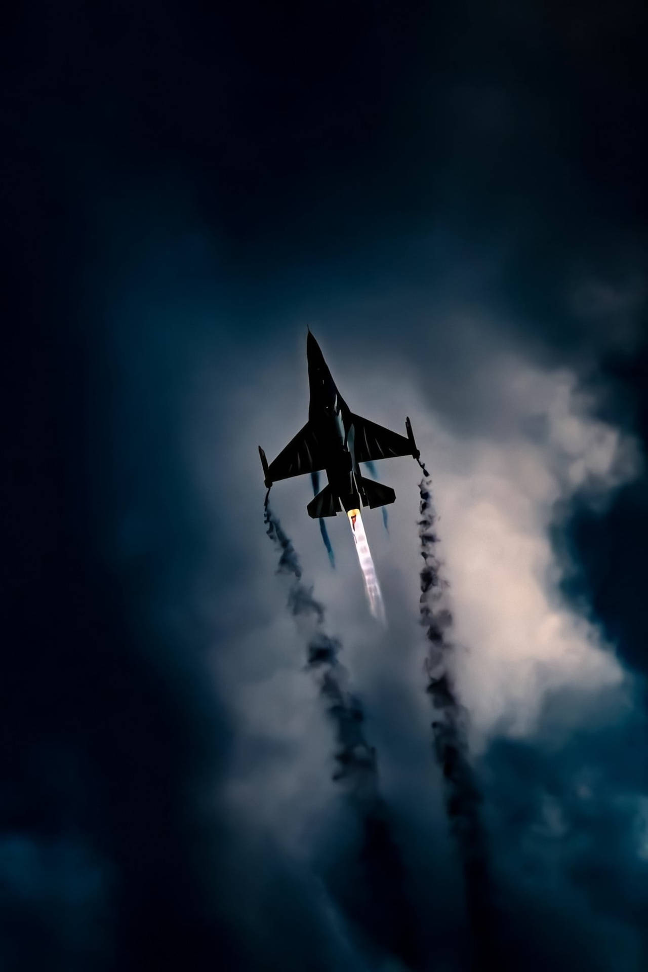戰鬥機在陰暗多雲的天空中留下煙霧痕跡攀升