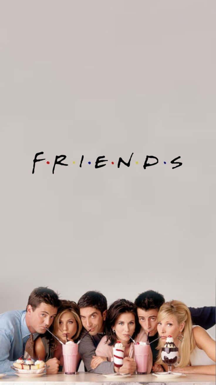 六位朋友在 Friends 電視節目標誌下拿著奶昔擺姿勢。