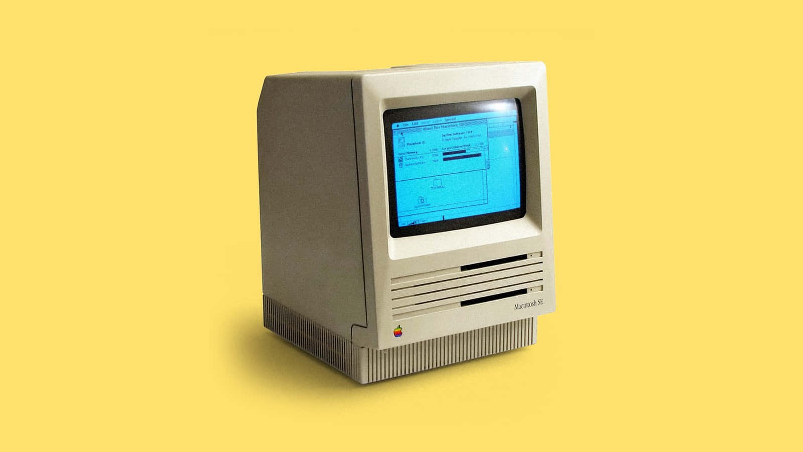 米色復古 Macintosh SE 電腦，藍色屏幕，黃色背景。