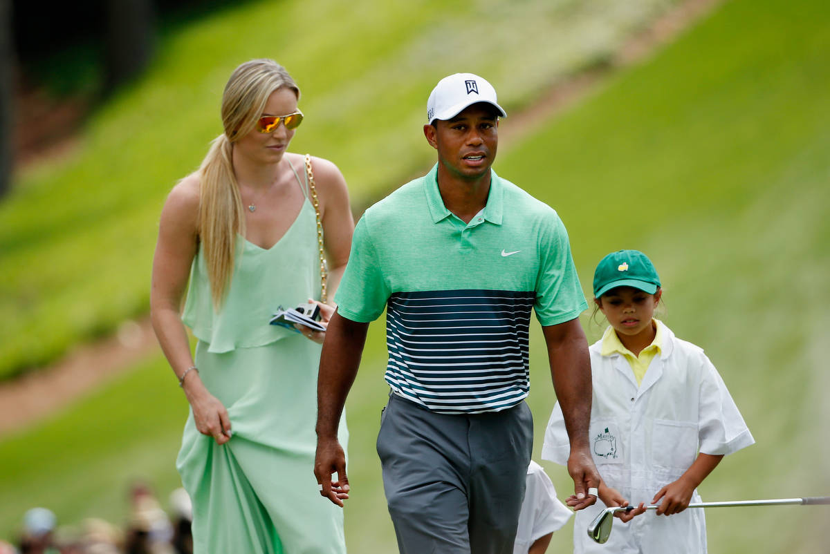 woods 桌布 壁紙 — 老虎活士與妻子和女兒在陽光明媚的高爾夫球場上散步，身穿綠色條紋Polo衫和帽子。