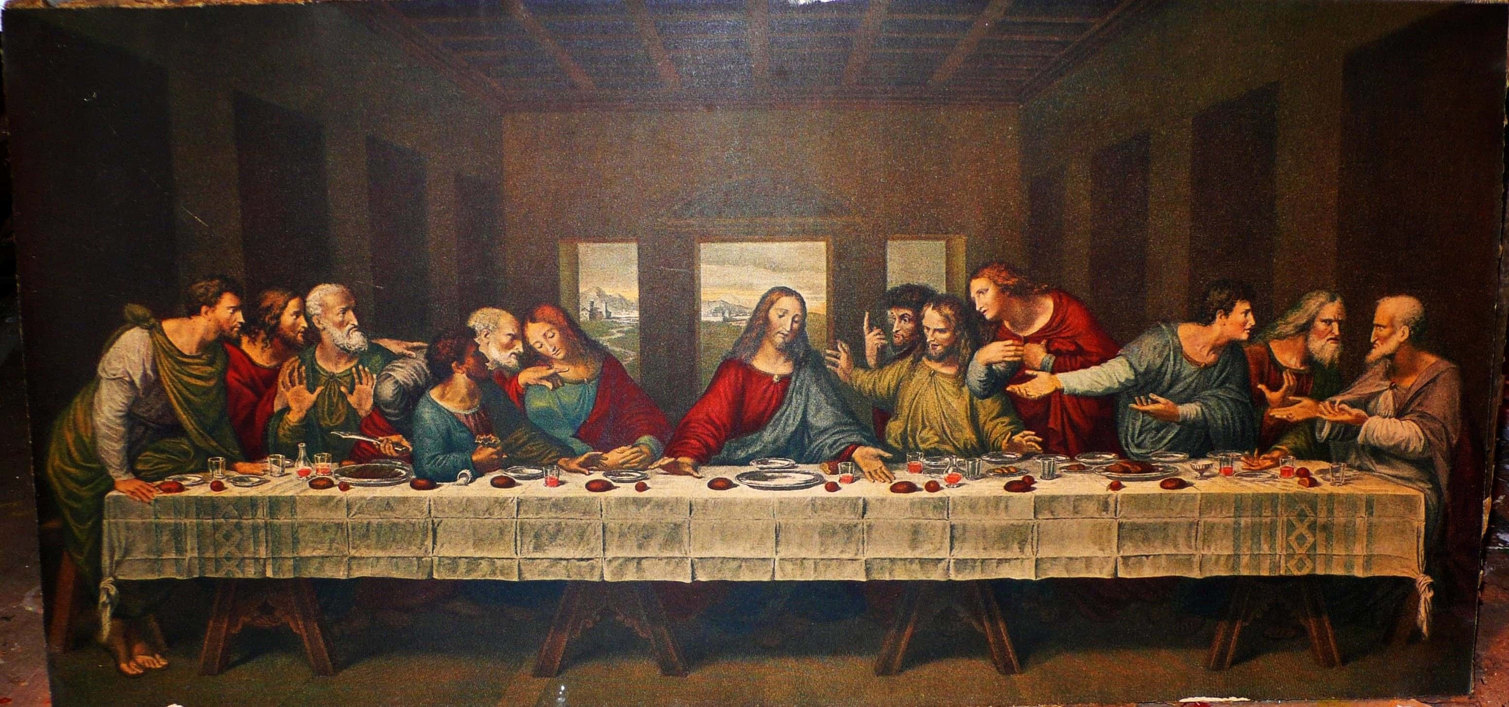 The Last Supper 桌布 壁紙 — 耶穌和祂的門徒在最後的晚餐期間，在一個燈光昏暗的房間裡圍著一張長桌，帶有戲劇性的明暗對比光線。