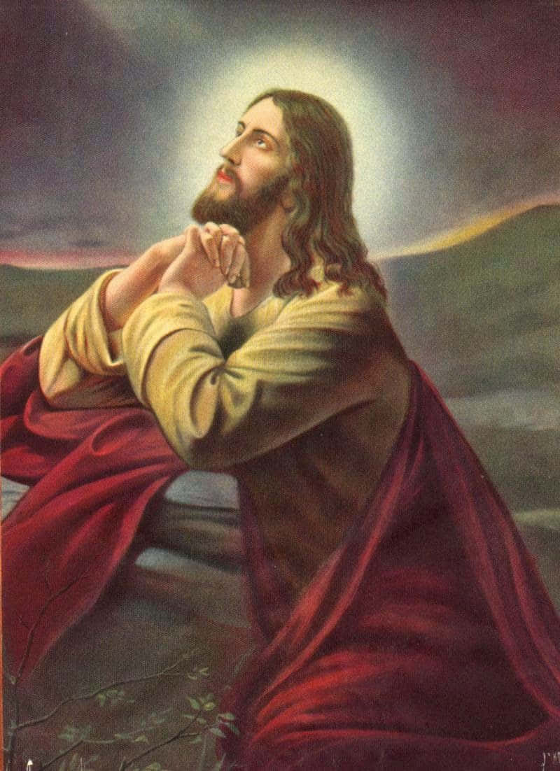 耶穌禱告 壁紙 — 耶穌基督雙手合十祈禱，光環在頭頂發光，背景是黃昏的天空。
