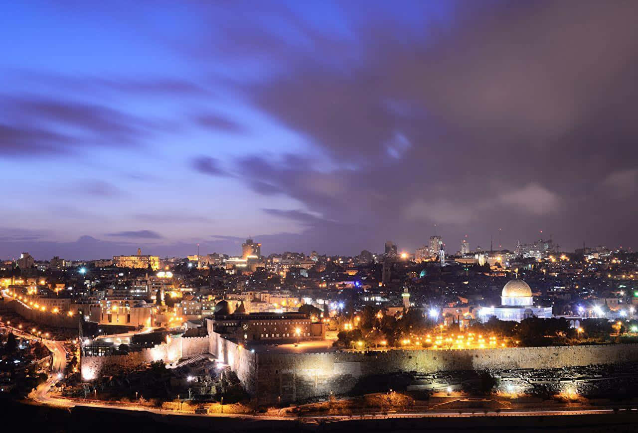 Israel 桌布 壁紙 — 耶路撒冷歷史城區的夜景全景，在深藍色暮色天空下，溫暖的燈光閃爍。