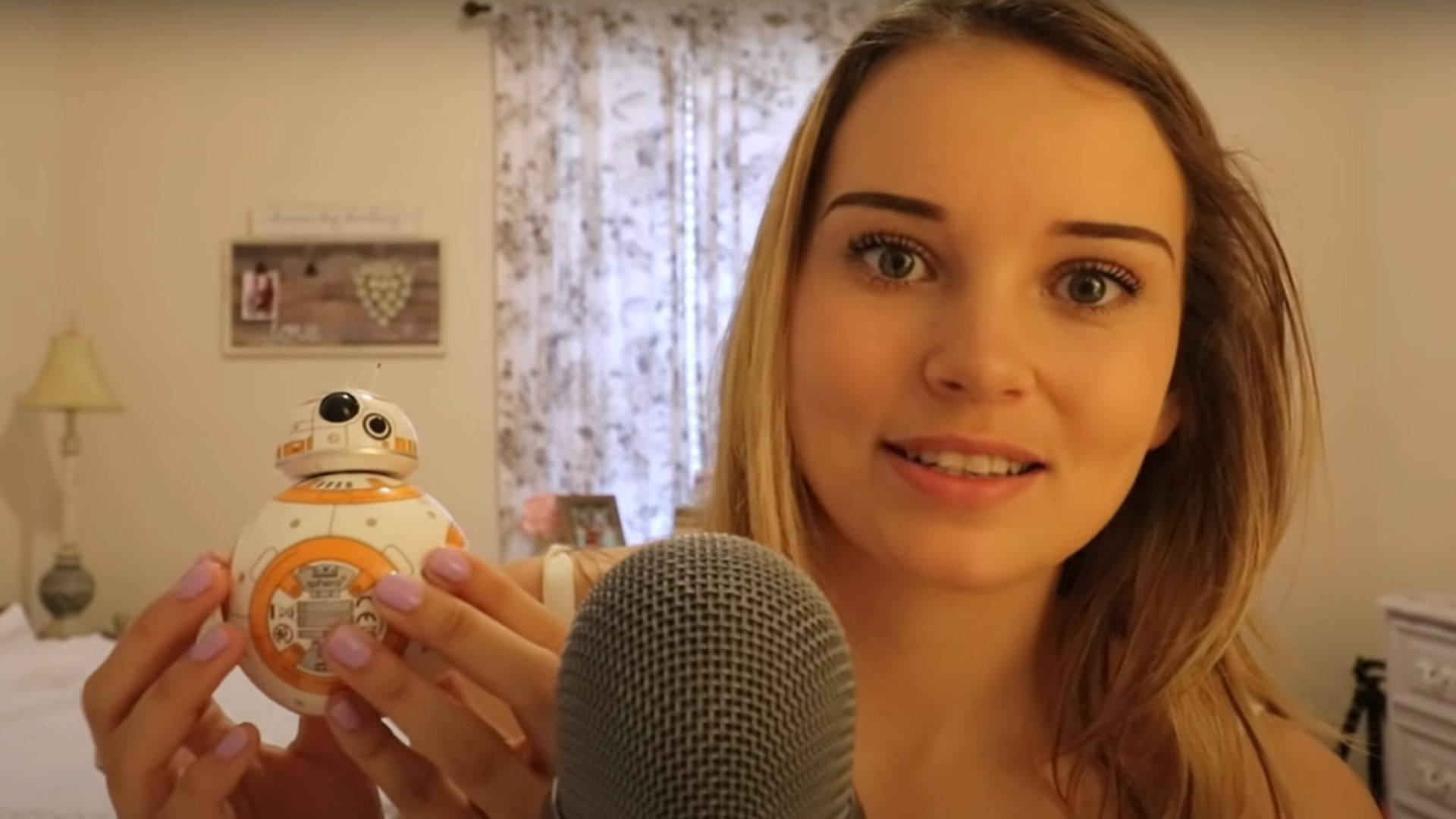 女性在臥室裡拿著BB-8機械人玩具靠近咪高峰。