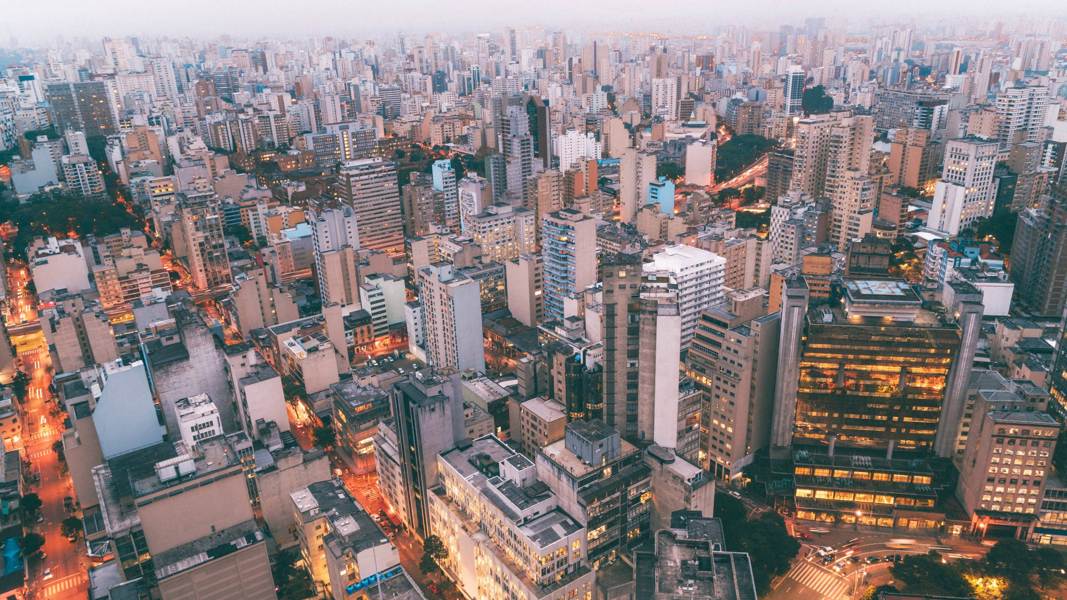聖保羅巴西美學城市景觀 壁紙 — 黃昏時分廣闊城市景觀的鳥瞰圖，溫暖的路燈在高聳建築物之間閃爍。
