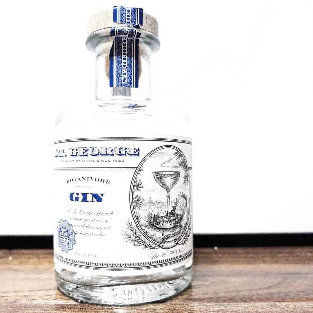St George Botanivore Gin 酒瓶放在木質表面上，背景為白色。