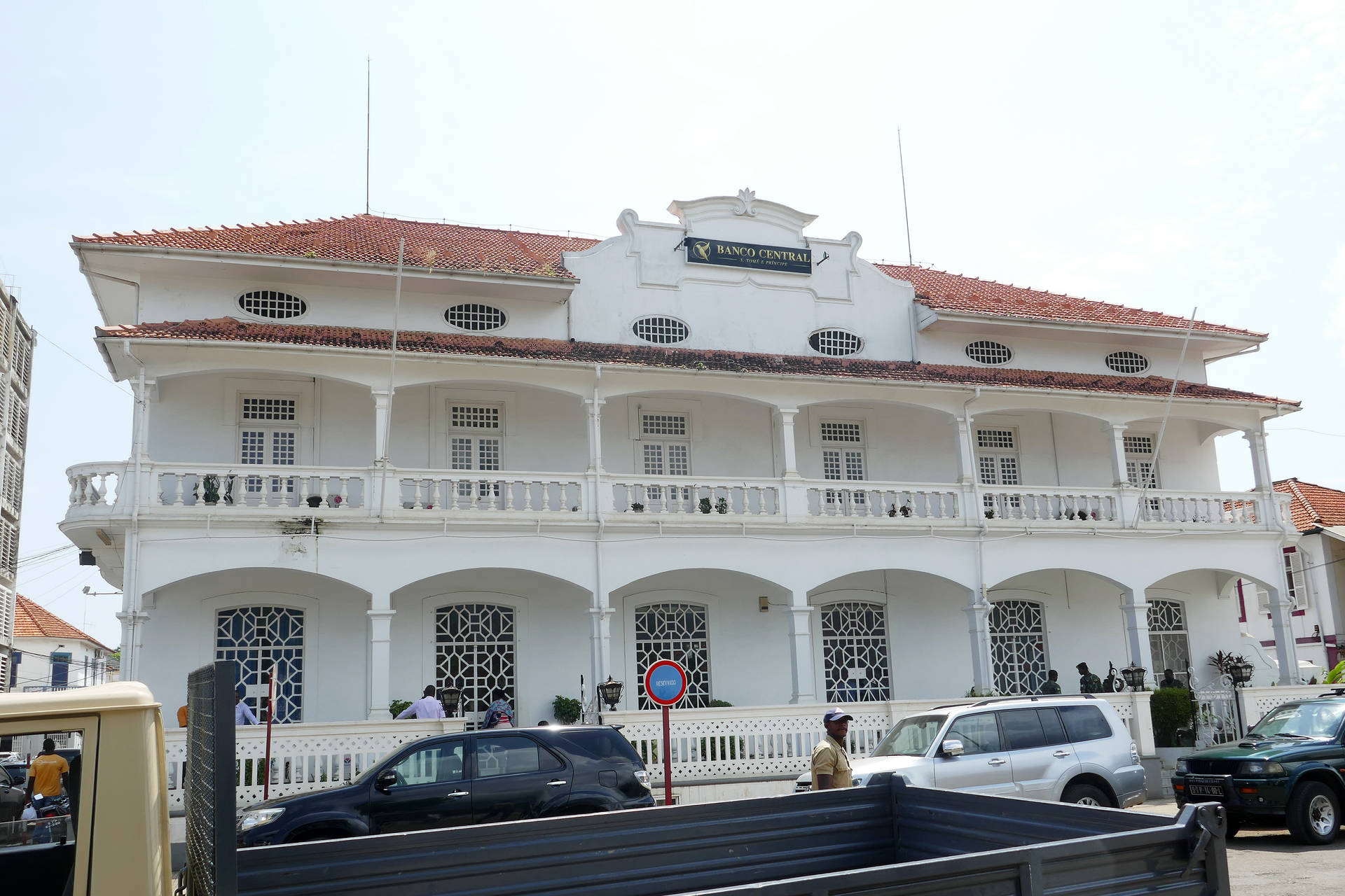 白色殖民建築，紅色屋頂，街上停有汽車