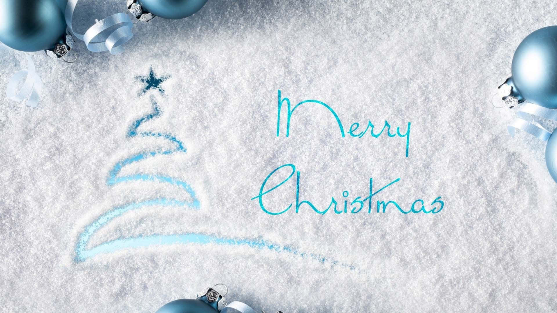 雪地表面，有繪製的聖誕樹和「聖誕快樂」訊息，周圍環繞著藍色裝飾品。