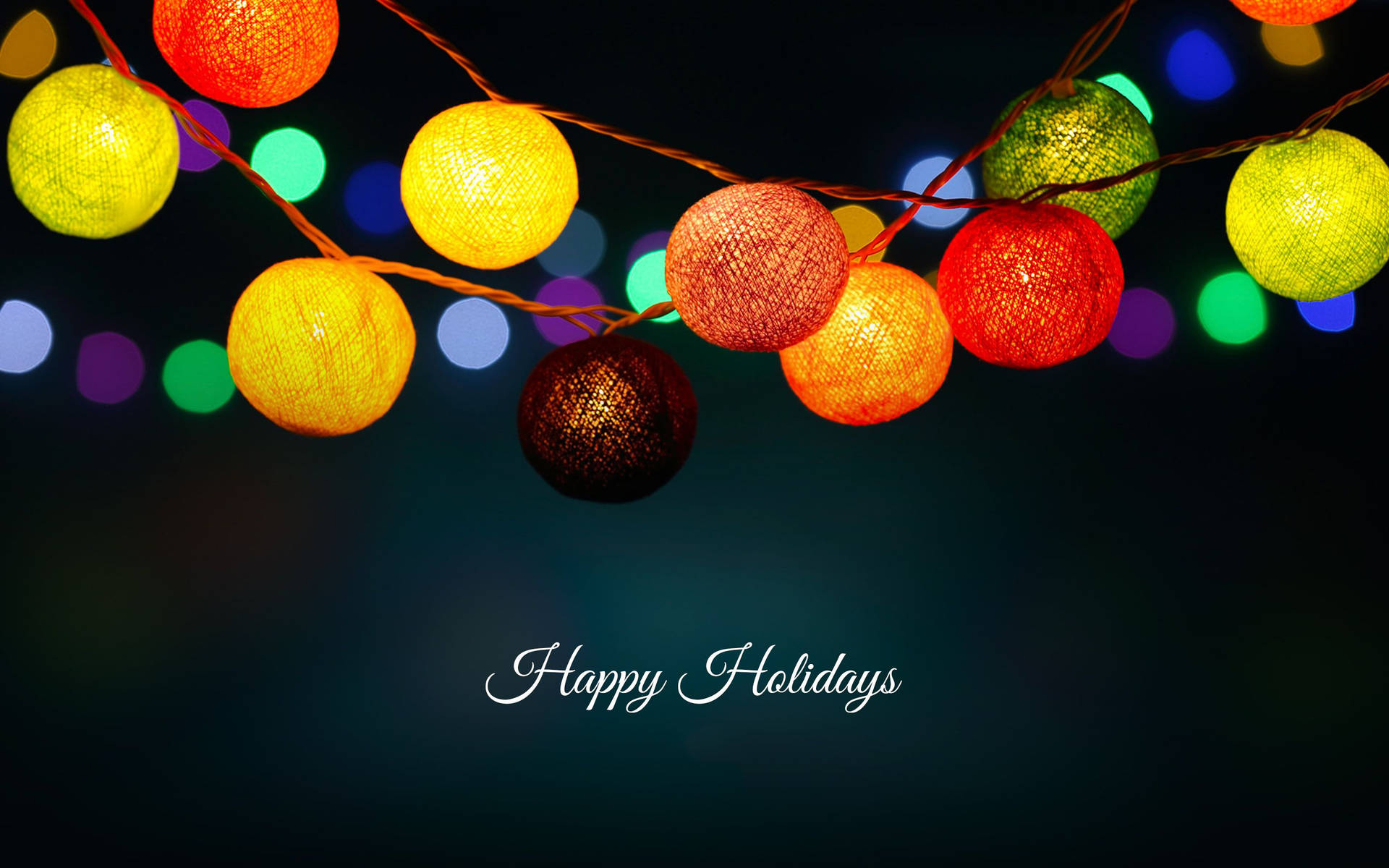 在黑暗背景上帶有「Happy Holidays」文字的彩色編織節日燈。
