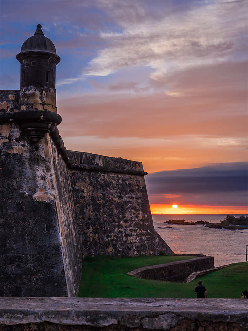 日落時分的歷史石頭堡壘，海洋和天空呈現溫暖色調。