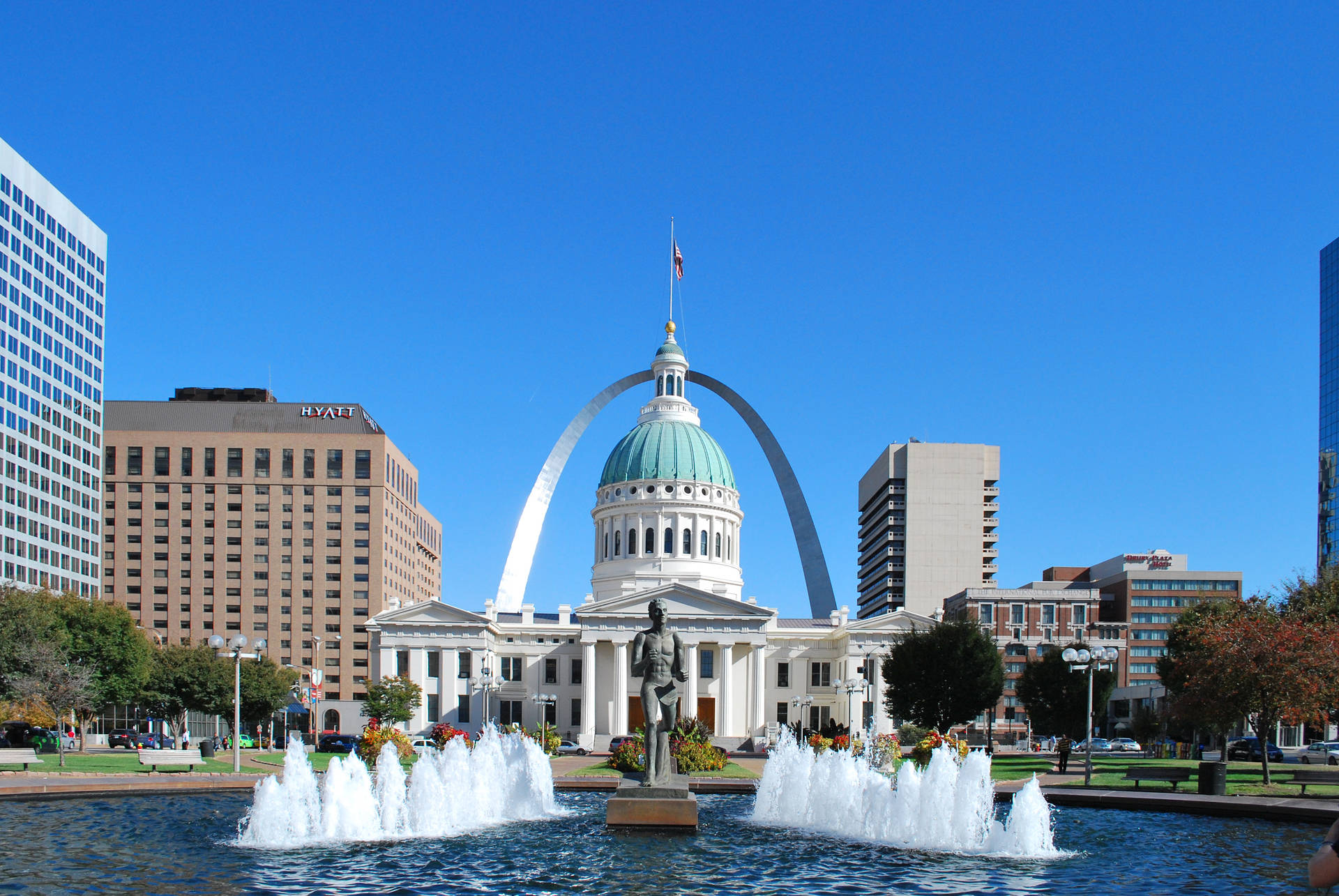 Gateway Arch 和舊法院大樓，在陽光明媚的城市公園中有噴泉。