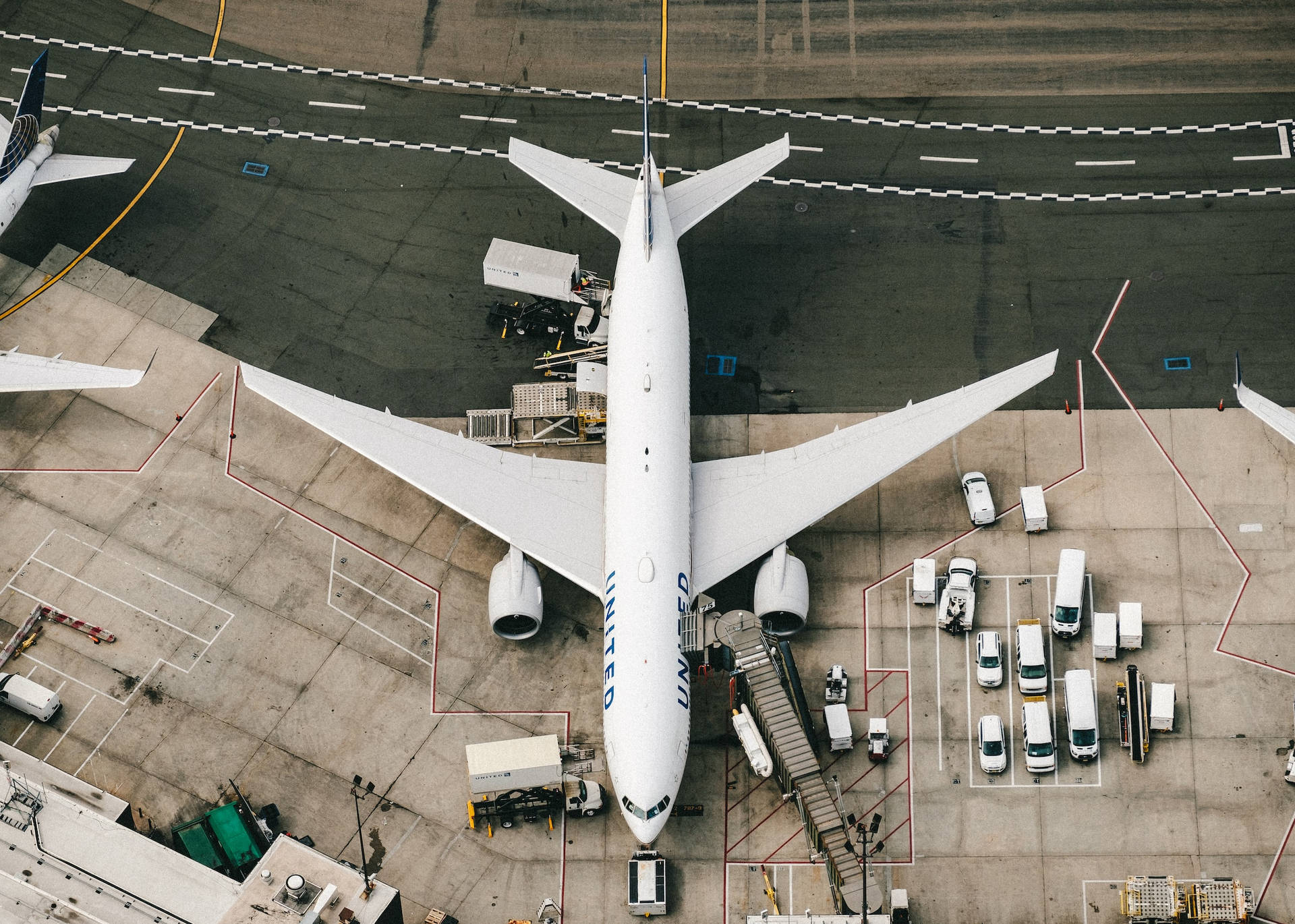聯合航空飛機停泊在機場閘口，附近有服務車輛。