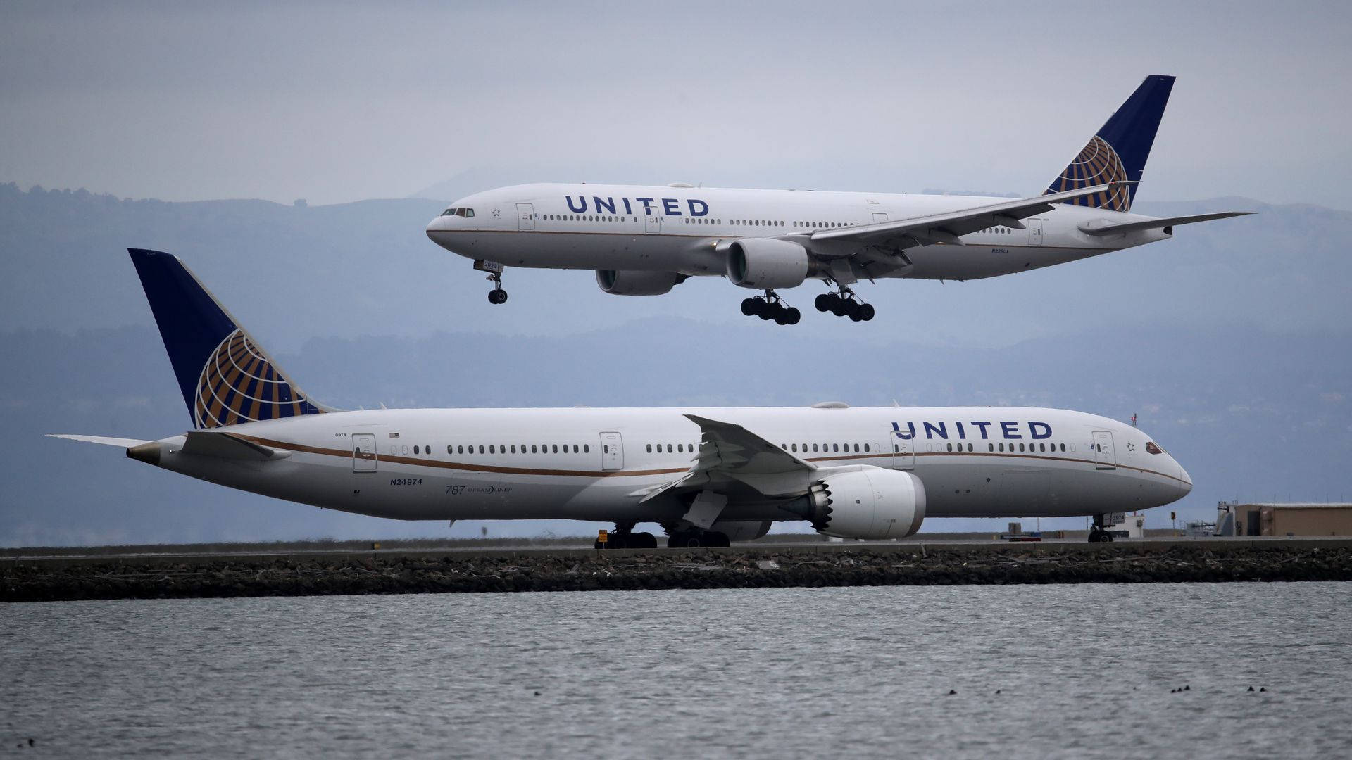 兩架聯合航空飛機，一架正在起飛，另一架在水邊滑行