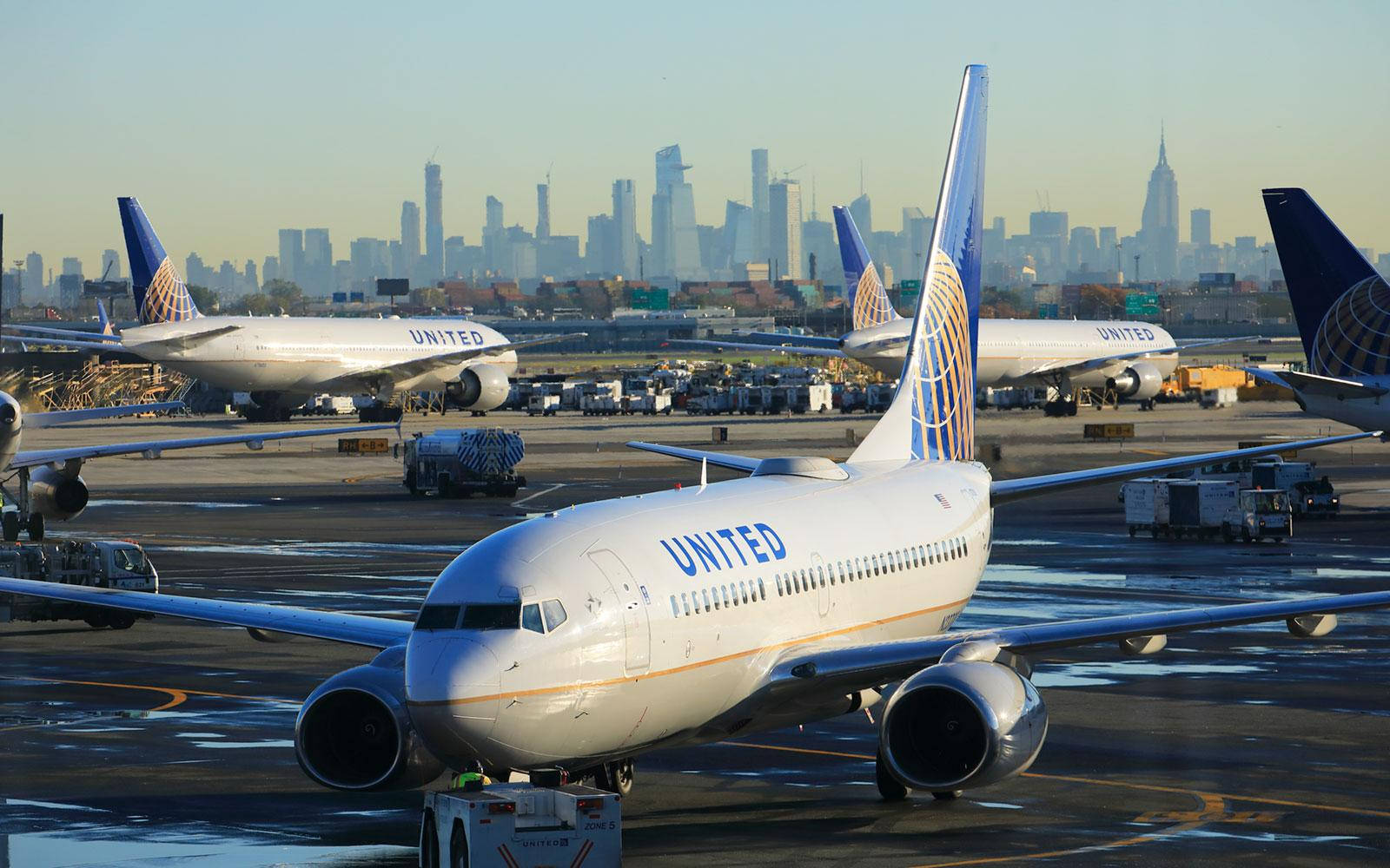 聯合航空的飛機在機場，背景是紐約市天際線在黎明時分。