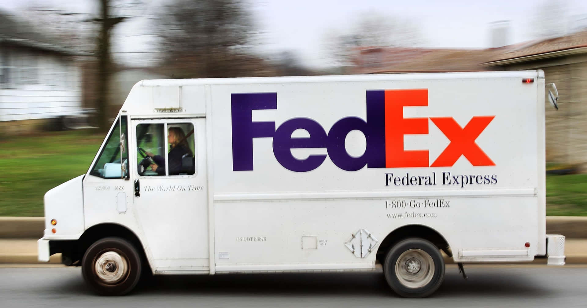 FedEx送貨車在郊區街道上行駛。