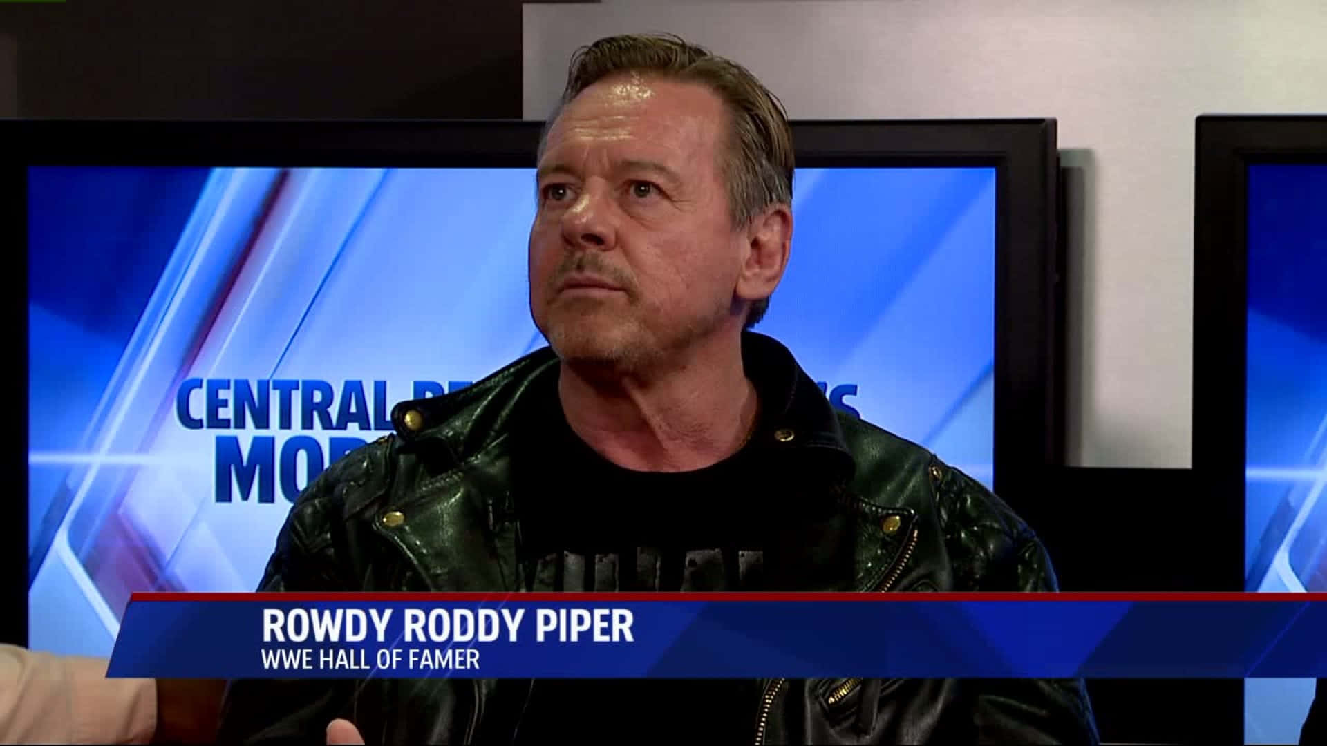 WWE名人堂成員 Rowdy Roddy Piper 在新聞採訪中身穿皮褸。