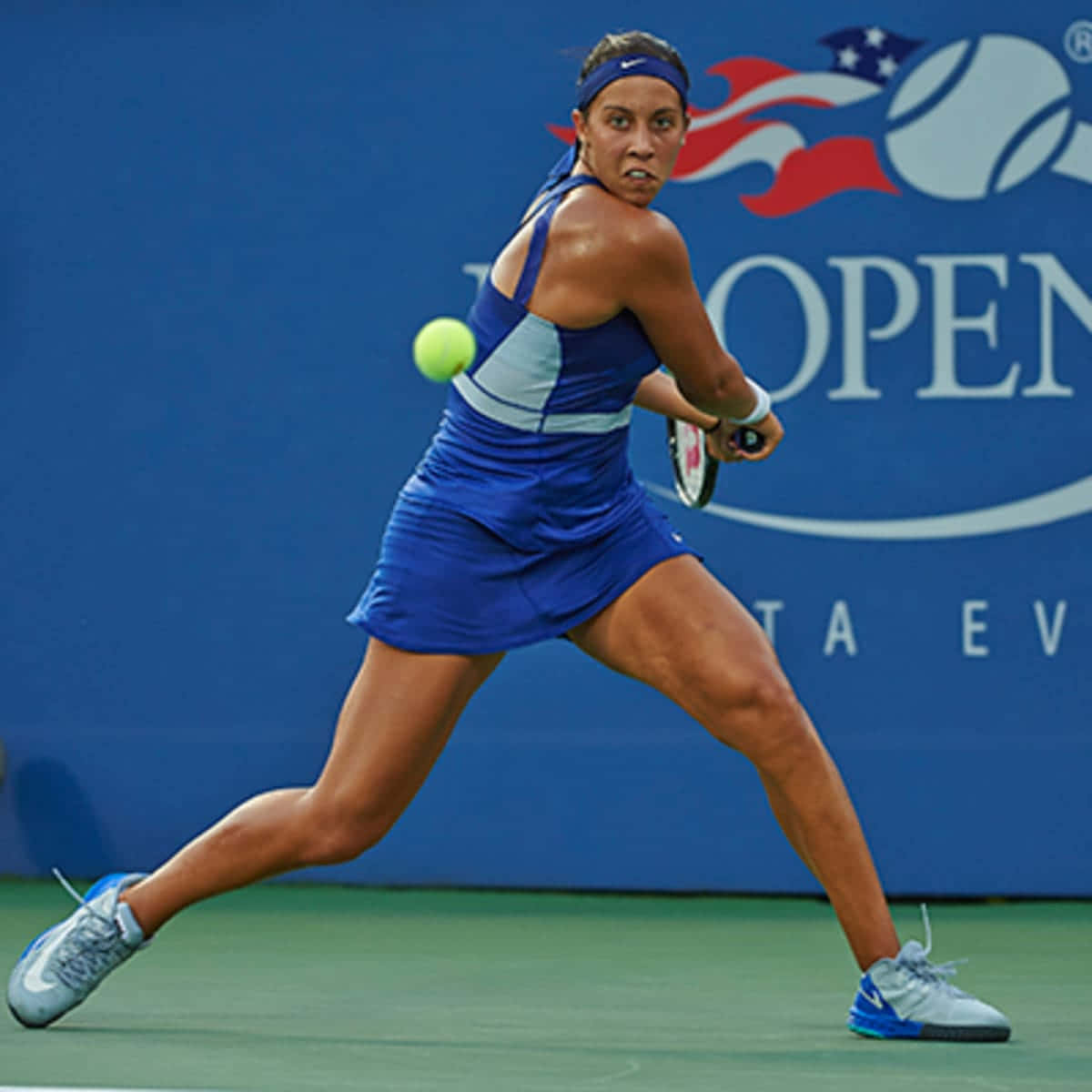 女網球手在 US Open 比賽期間於綠色球場上揮拍。