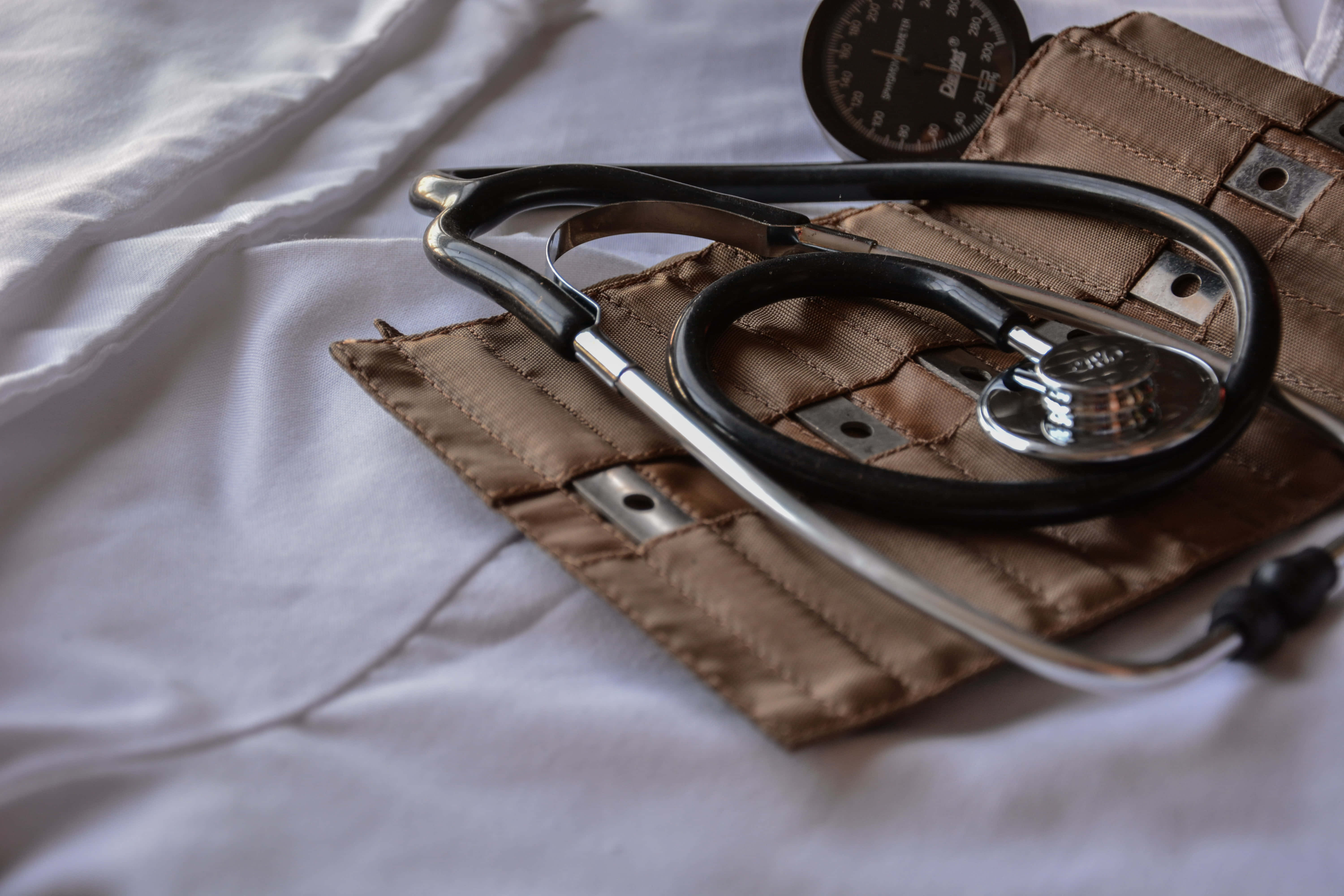 Stethoscope 桌布 壁紙 — 聽診器和血壓袖帶放在臨床環境中潔白的床單上。