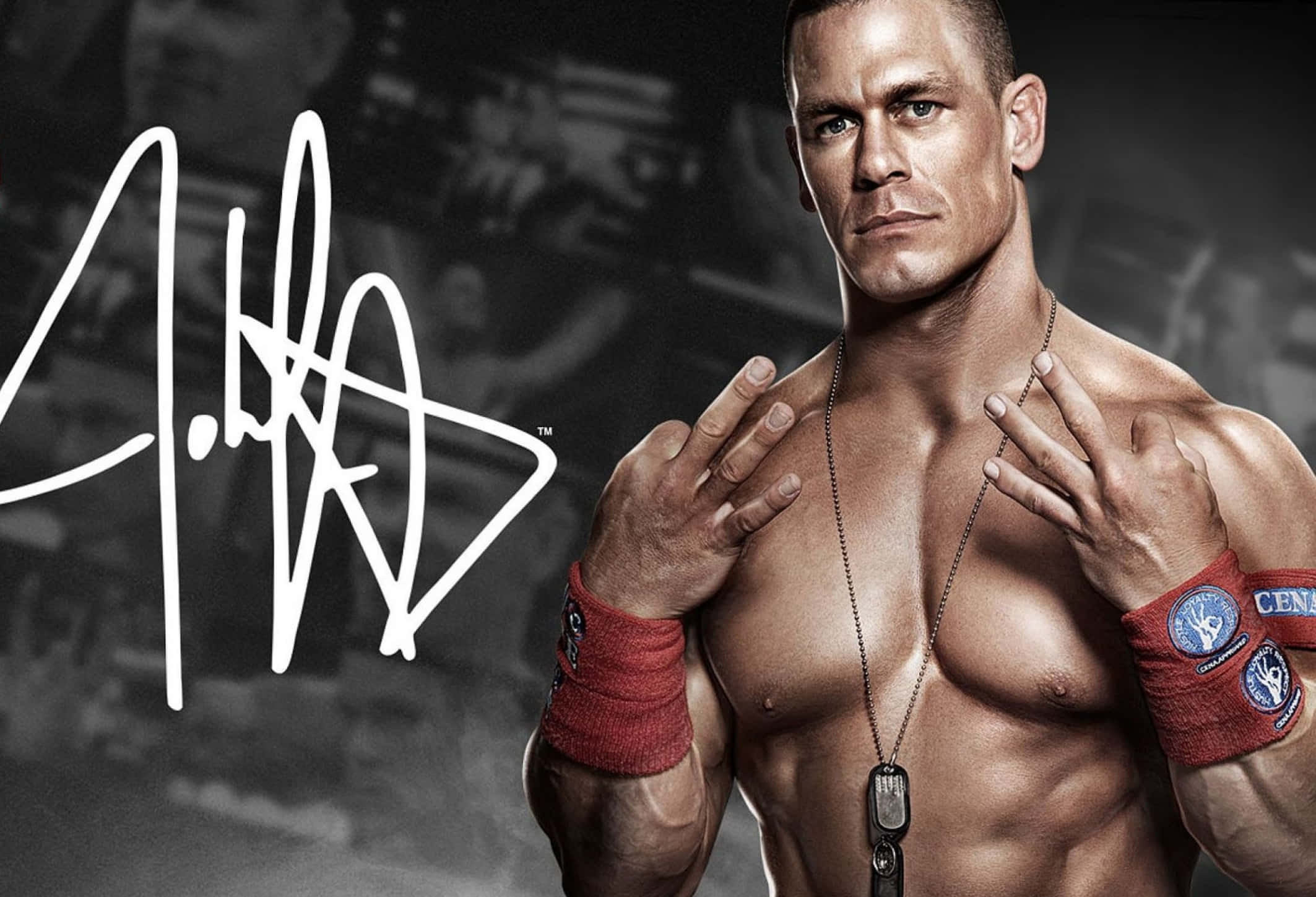 WWE 桌布 壁紙 — 肌肉發達的摔角手 John Cena 在黑暗的健身室背景下，自信地擺出標誌性的手勢。