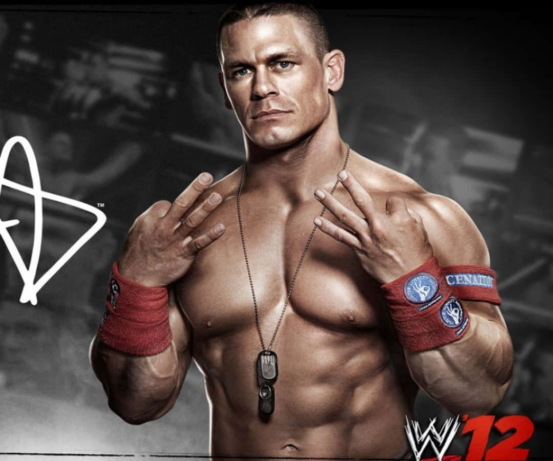 John Cena 桌布 壁紙 — 肌肉發達的摔角手約翰·辛納（John Cena）赤裸上身，佩戴紅色腕帶和狗牌，以黑暗模糊的摔角場地為背景擺姿勢。