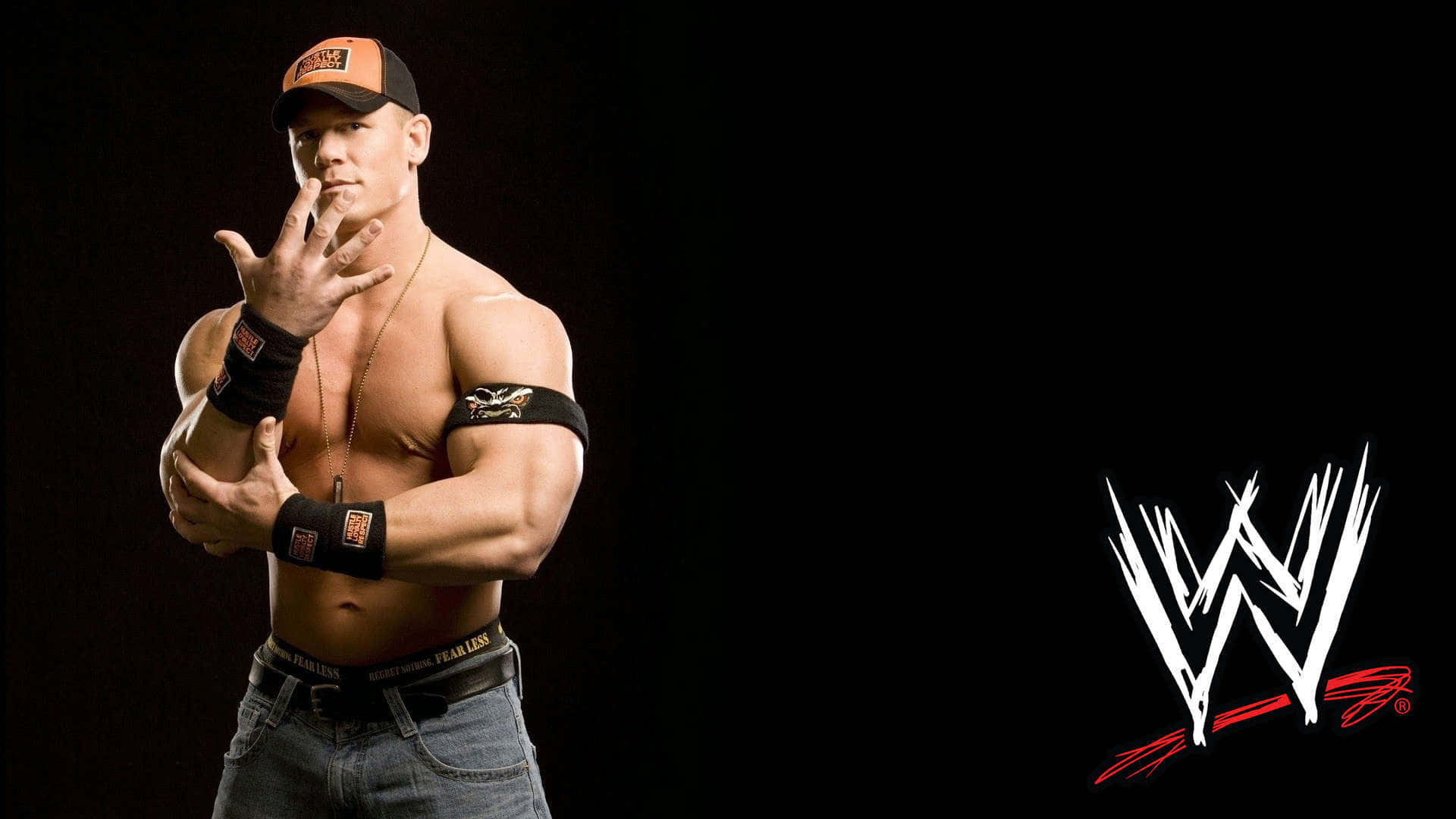 WWE 桌布 壁紙 — 肌肉發達的摔角手約翰·辛納戴著黑色和橙色帽子，在深色背景前自信地擺姿勢，帶有WWE標誌。