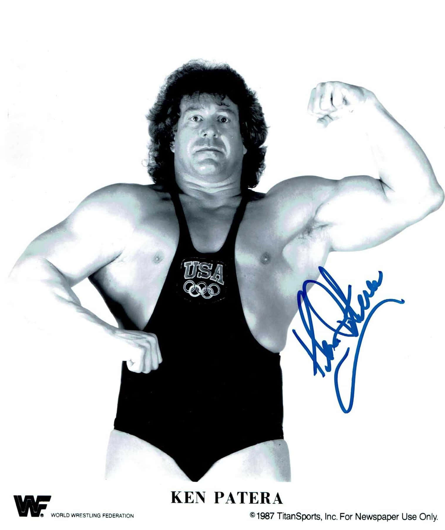 Ken Patera 身穿美國摔角緊身背心，展示二頭肌並帶有藍色簽名。