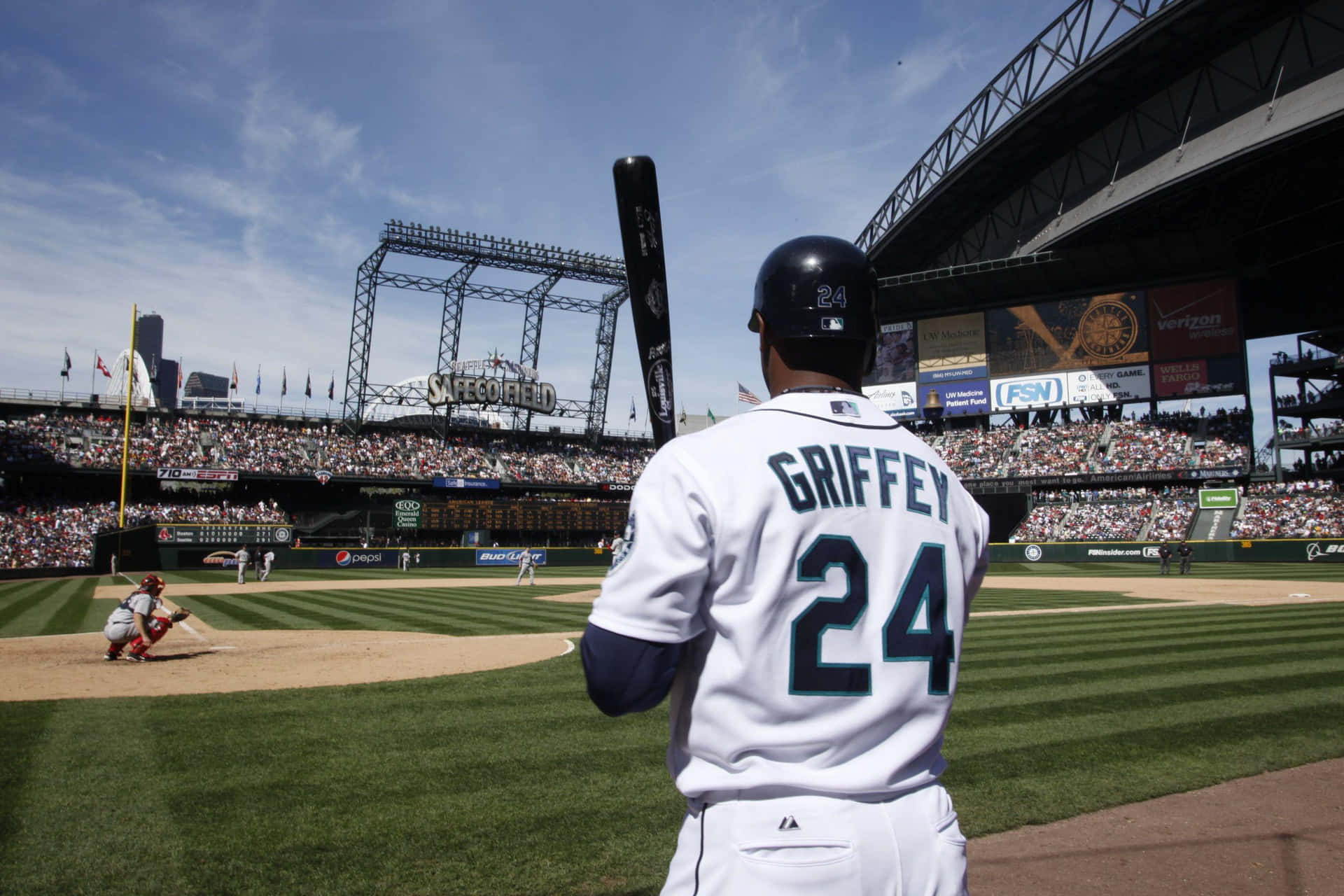 身穿白色球衣、印有 Griffey 名字和 24 號的棒球運動員在比賽中站在本壘板。
