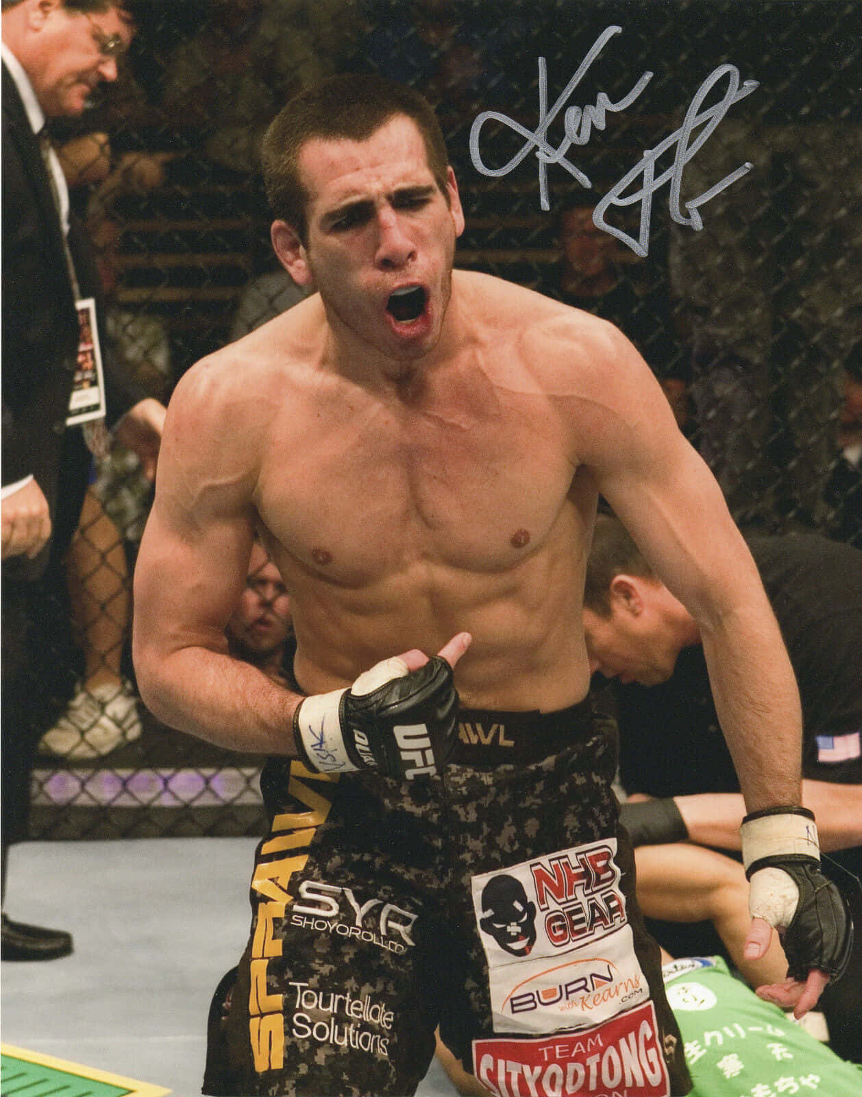MMA拳手在八角籠中展示簽名慶祝勝利。