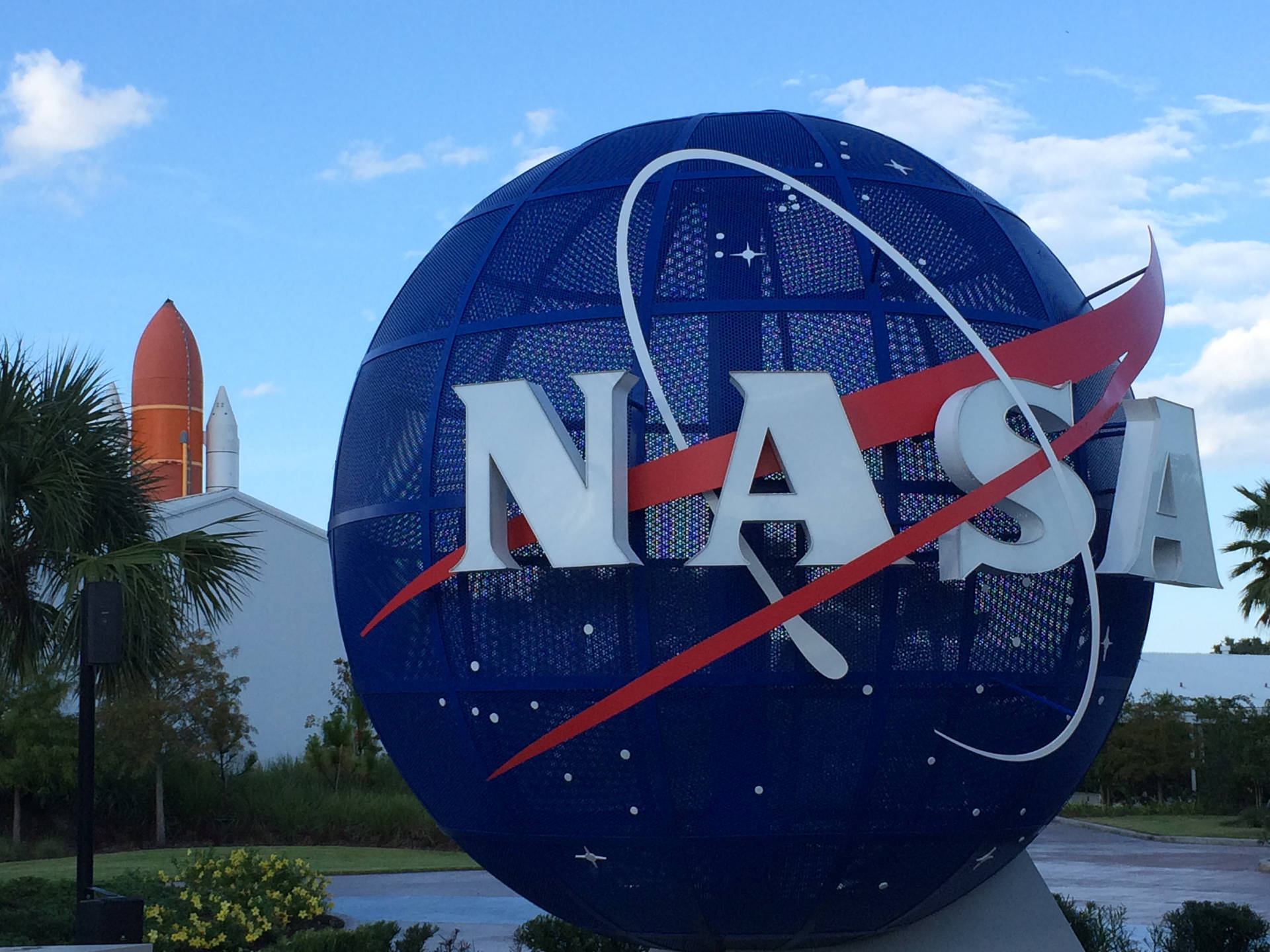 大型NASA標誌球體，背景有火箭，藍天下 — Nasa GIF 壁紙