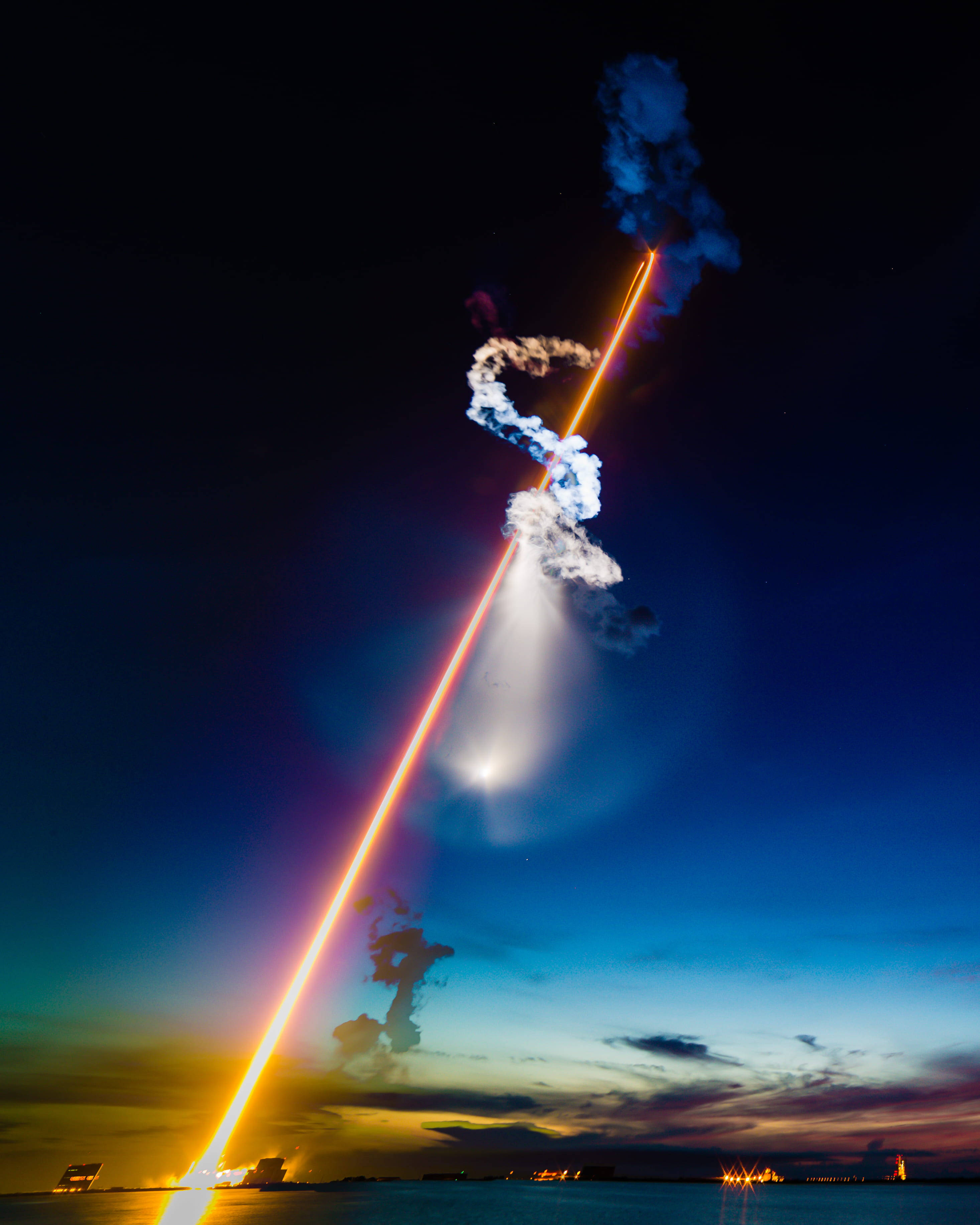 肯尼迪航天中心夜空尾燈軌跡 壁紙 — 一枚火箭在黃昏時升空，在漸變的天空中留下熾熱的軌跡和滾滾濃煙。