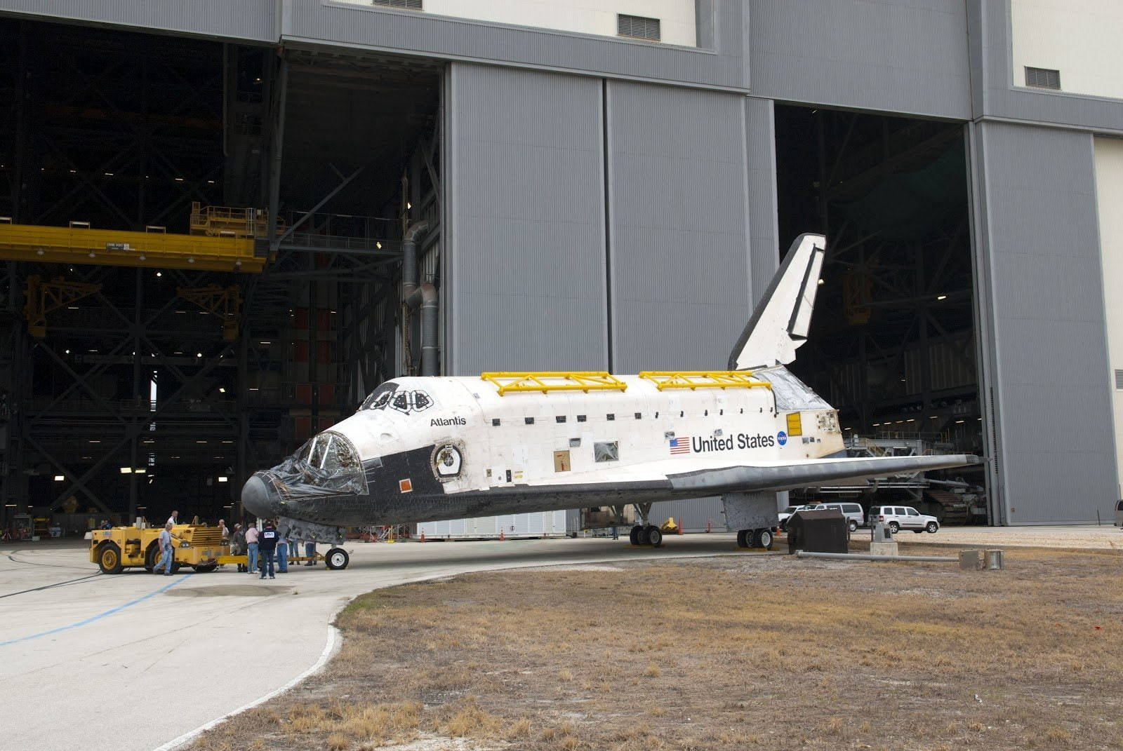 亞特蘭蒂斯號太空穿梭機在機庫外展示，有工人和車輛。 — Nasa GIF 壁紙