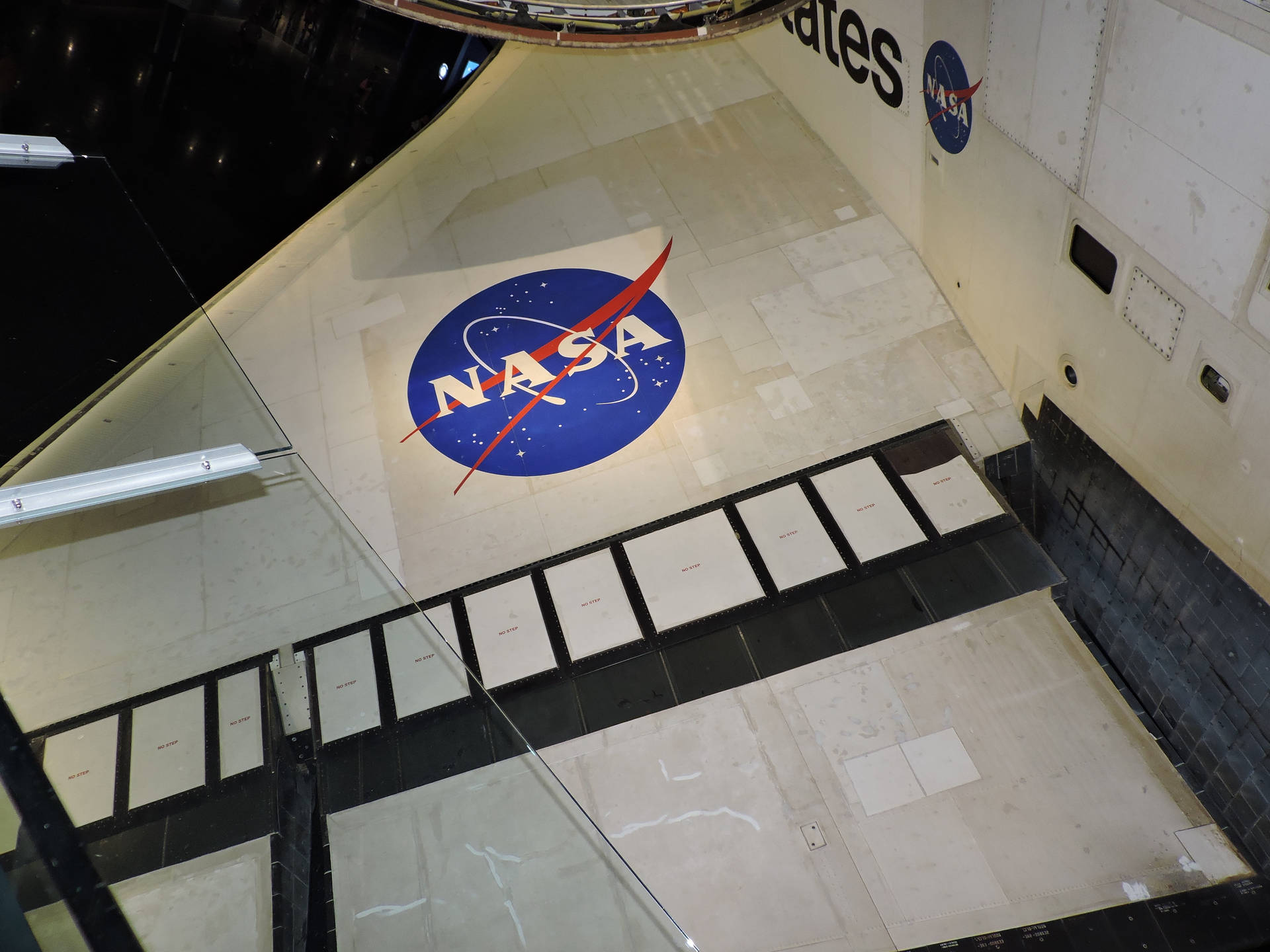 NASA標誌投射在太空船展覽館內的地板上，設有玻璃屏障。 — Nasa GIF 壁紙