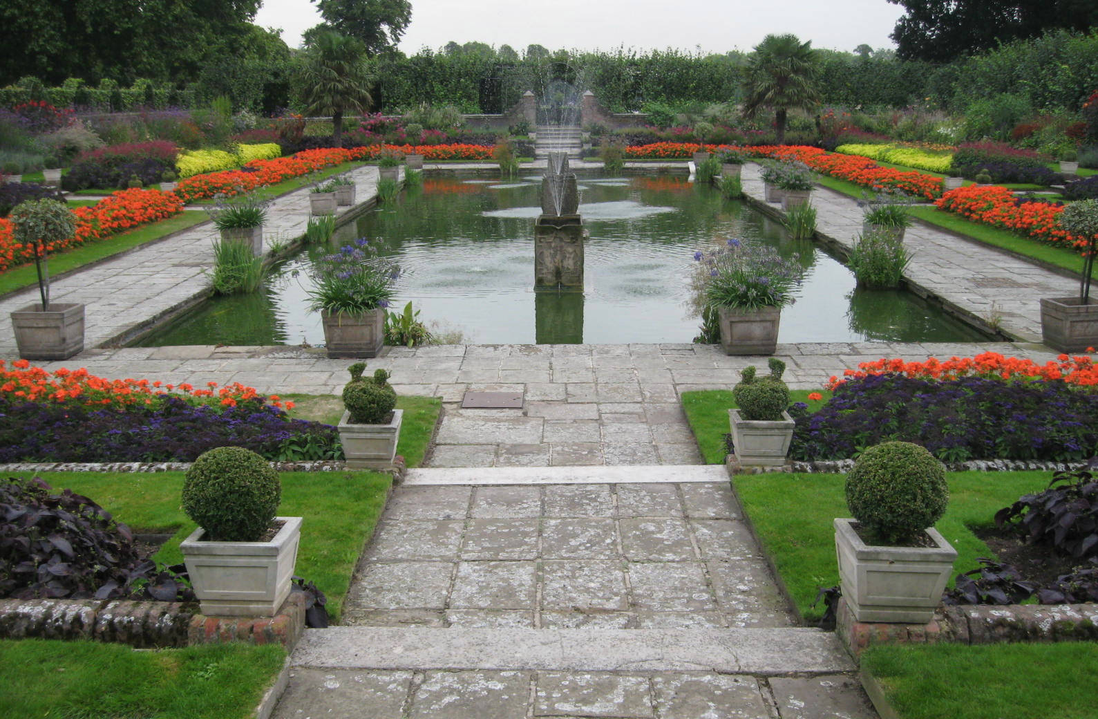 正式花園，設有石徑、倒影池和色彩繽紛的花壇。
