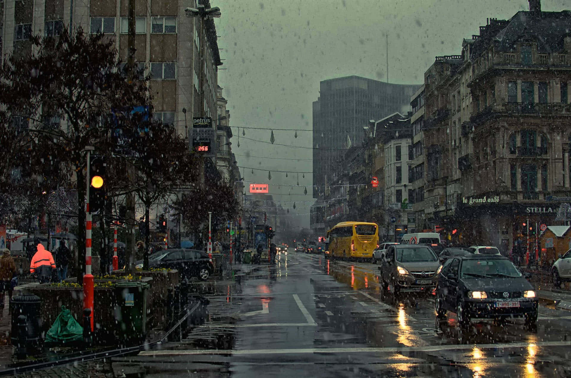 黃昏時分的城市街道，下雨且濕漉漉的路面反射光線。