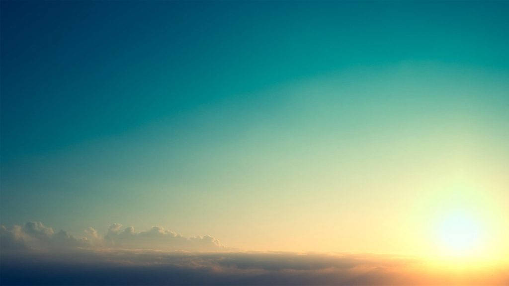 自然中的寧靜與平和 壁紙 — 日出將天空染成溫暖的金色和清涼的藍綠色，雲朵在升起的太陽下發光。