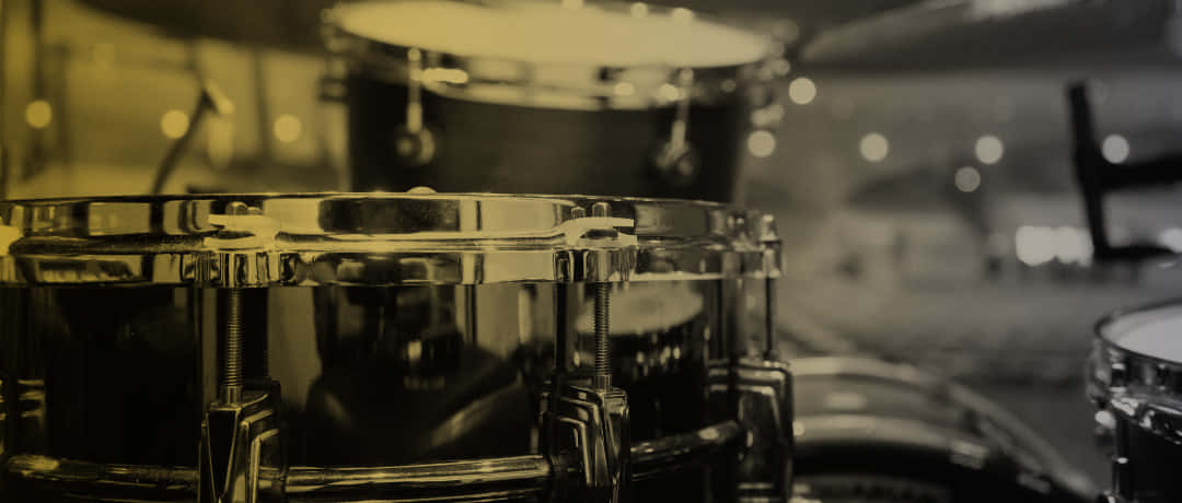 特寫：溫暖懷舊燈光下鼓組上的鉻合金鼓硬件。