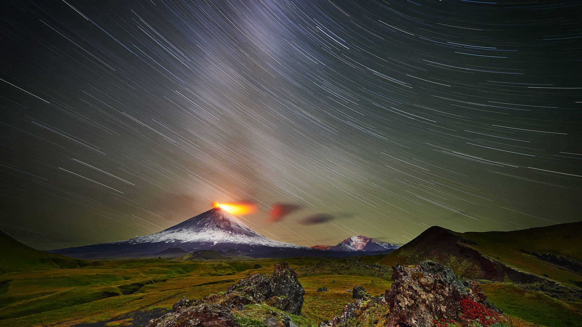 夜晚火山爆發，上方有星軌 — 鎖屏 壁紙