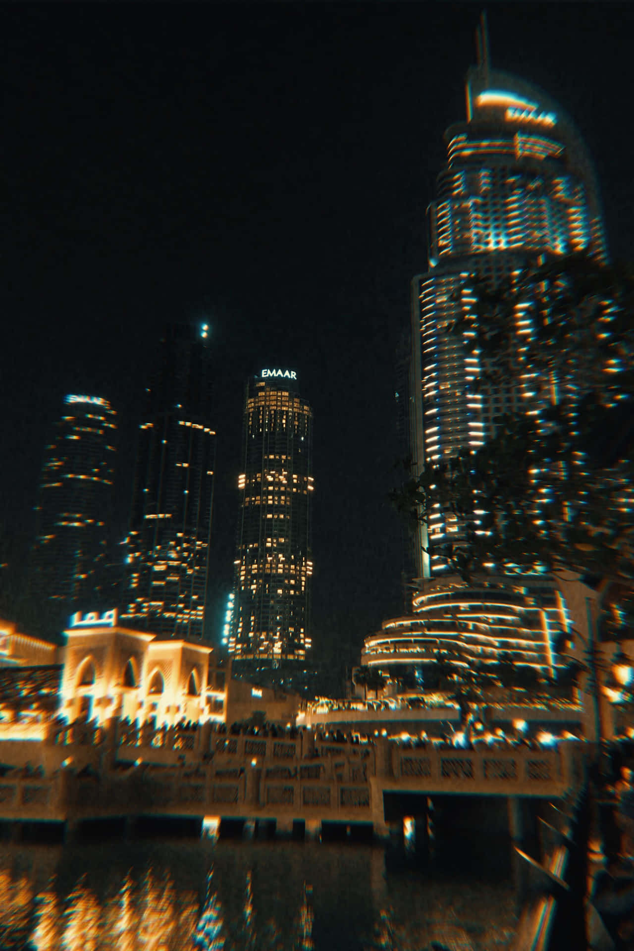 夜間城市天際線，發光的摩天大樓和水面倒影。