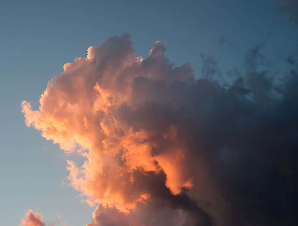 自然之美盡顯於這片寧靜的藝術感雲朵風景 壁紙 — 一團戲劇性的雲在深藍色暮色天空中呈現火橙色光芒。