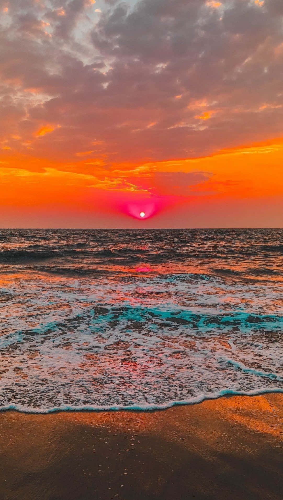 海洋上的日落，天空色彩繽紛，海浪拍打沙灘
