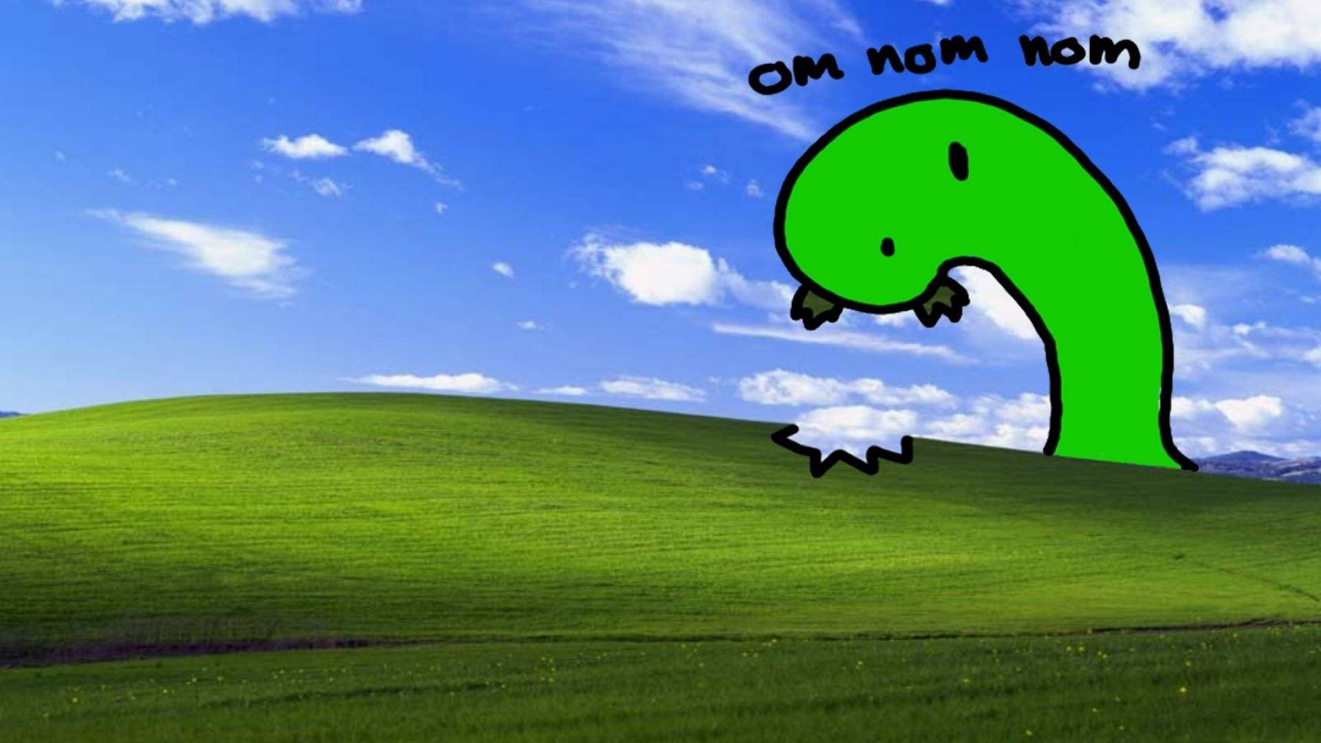 自然棲息地中的美麗蚯蚓 壁紙 — 一隻綠色卡通恐龍，帶有「om nom nom」文字，在藍天白雲下起伏的綠色山丘上吃草。